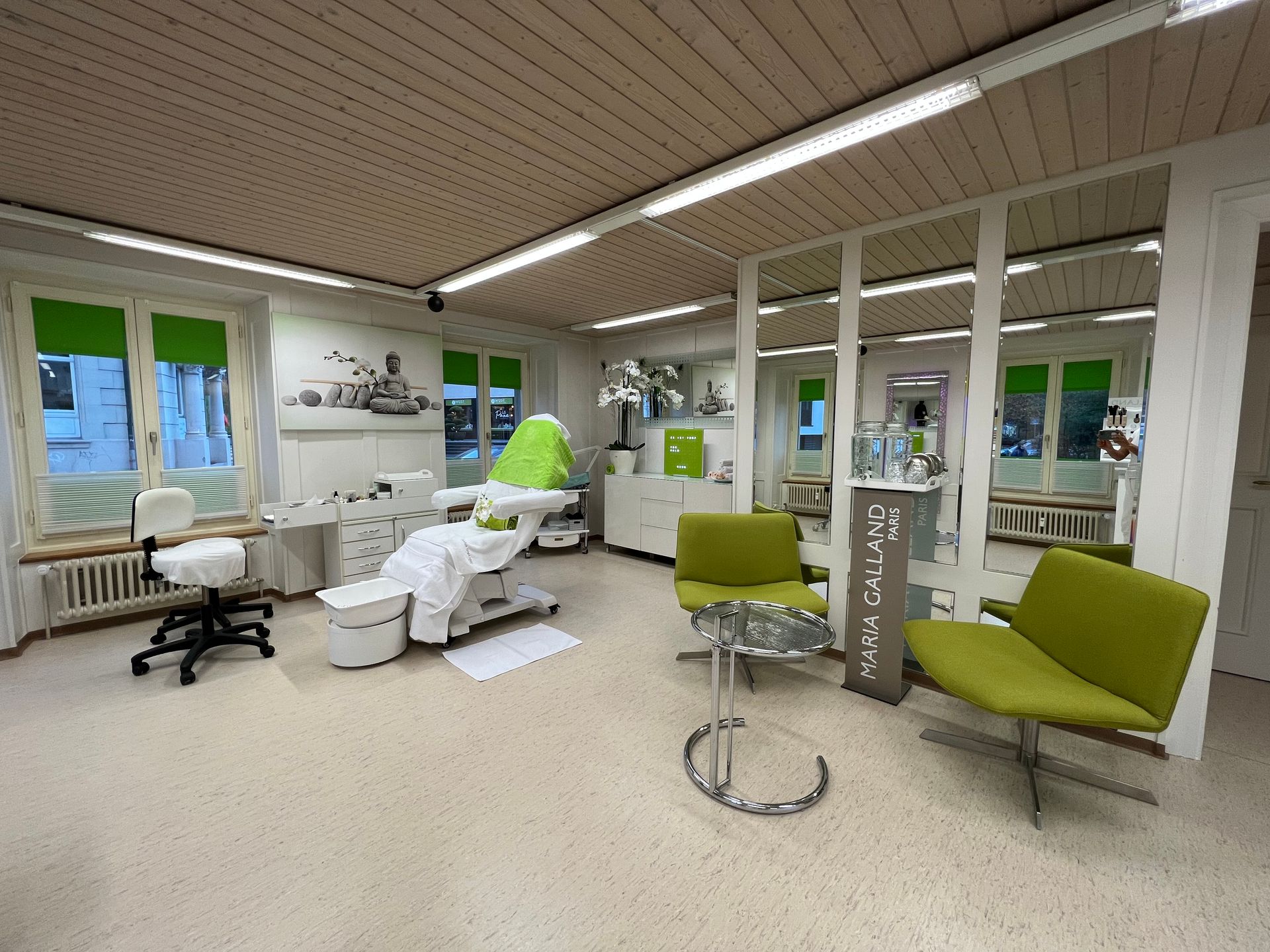 Ein grosser Behandlungsraum mit einer Couch, Stühlen und einem Tisch.