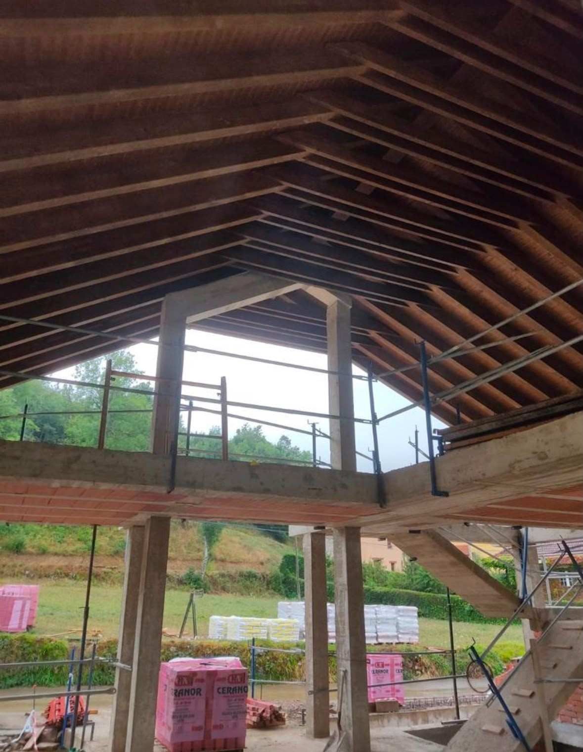 Hormigón fresco extendiéndose y nivelándose sobre una rejilla de barras de refuerzo al aire libre.