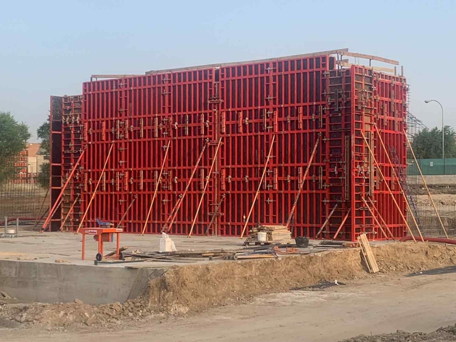 Obrero de la construcción vertiendo hormigón en un gran cubo desde una mezcladora.