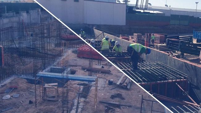 Obreros de la construcción en una obra con andamios, barras de refuerzo y encofrados de hormigón bajo la luz del sol.