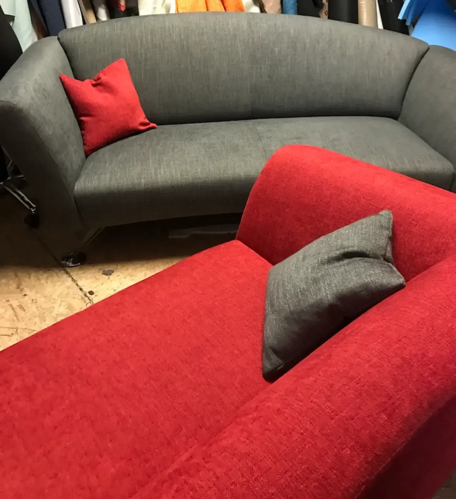 Graues Sofa mit rotem Kissen, rote Chaiselongue mit grauem Kissen, Innenraum.