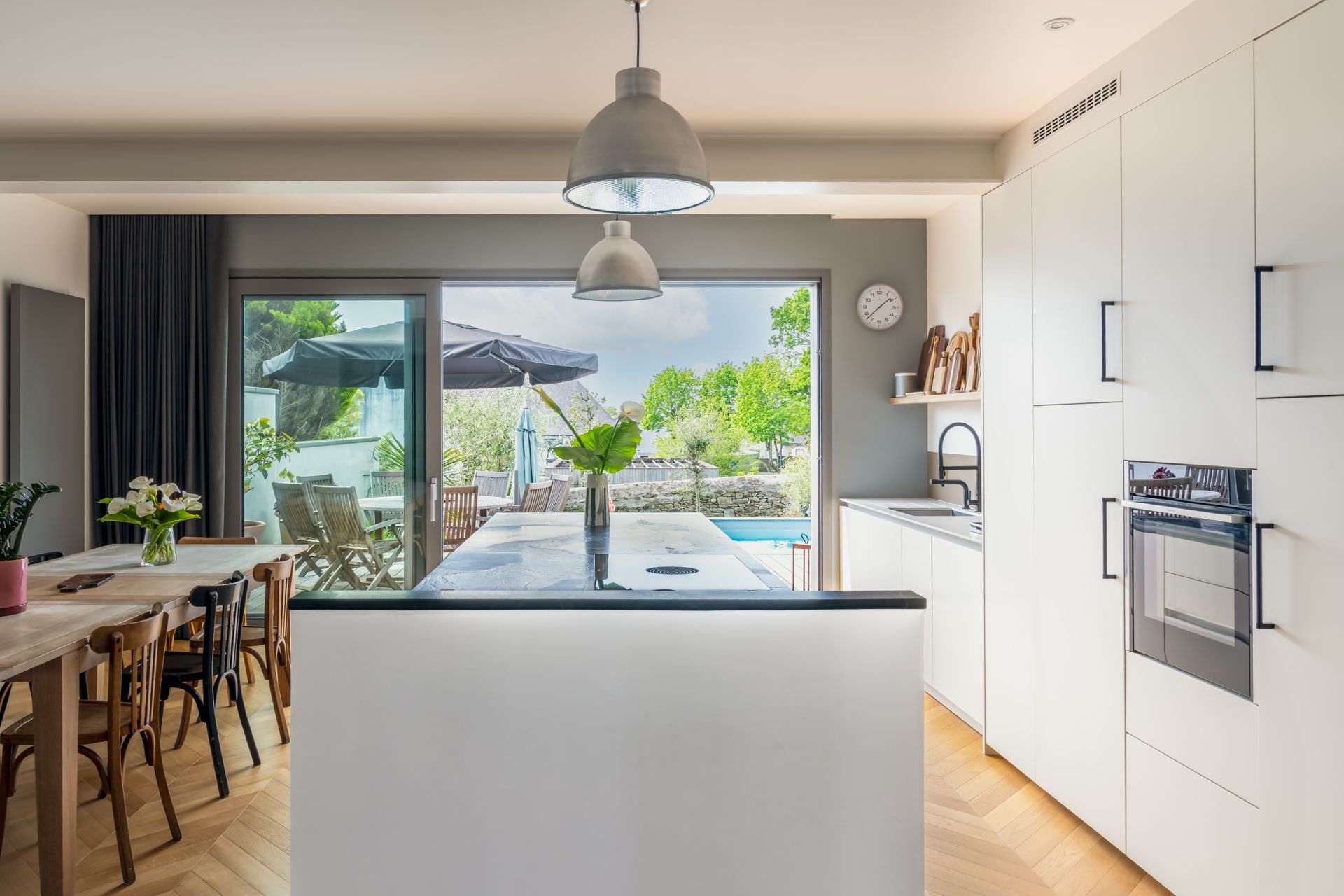 Cuisine moderne avec îlot central, placards blancs
