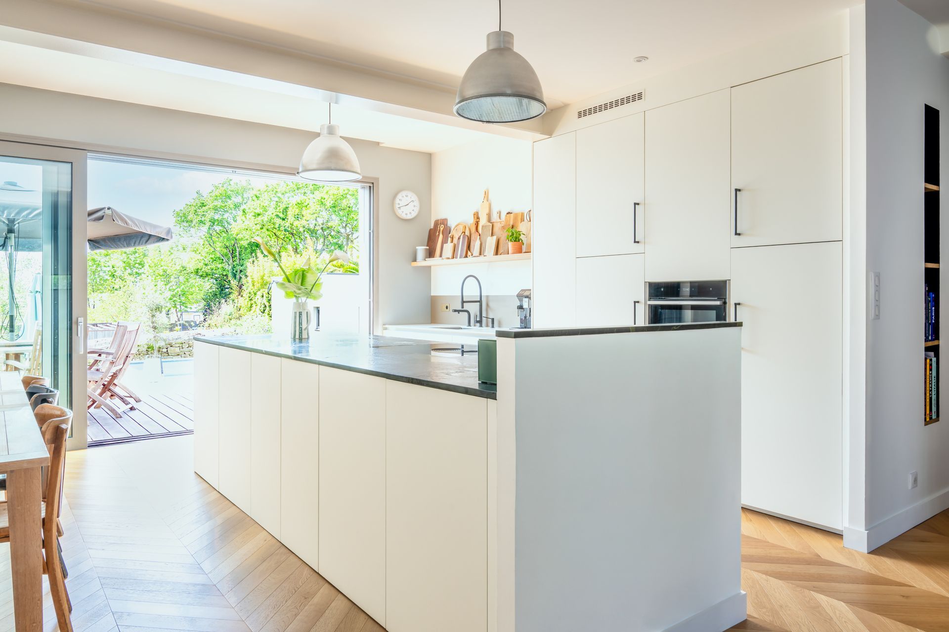 Cuisine moderne et lumineuse avec des placards blancs, un îlot central