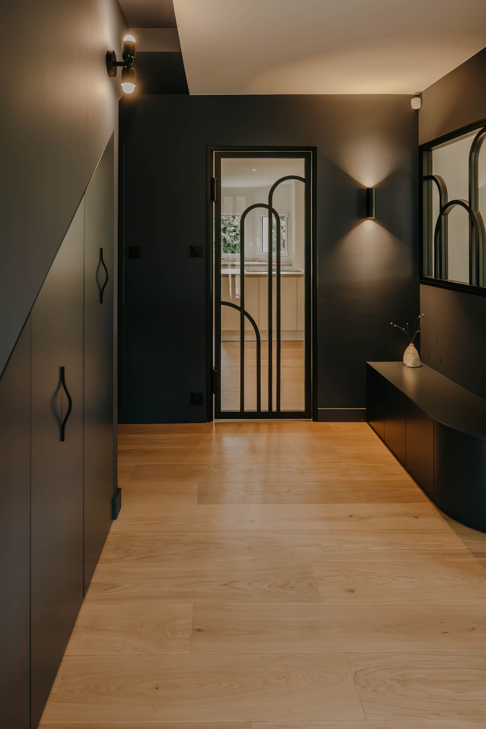 Couloir moderne aux murs sombres, au sol en bois