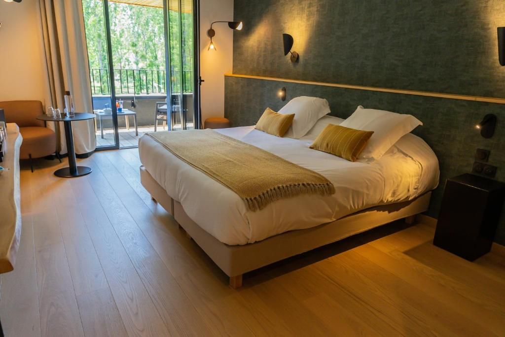 Chambre moderne avec un grand lit, un mur d’accent vert