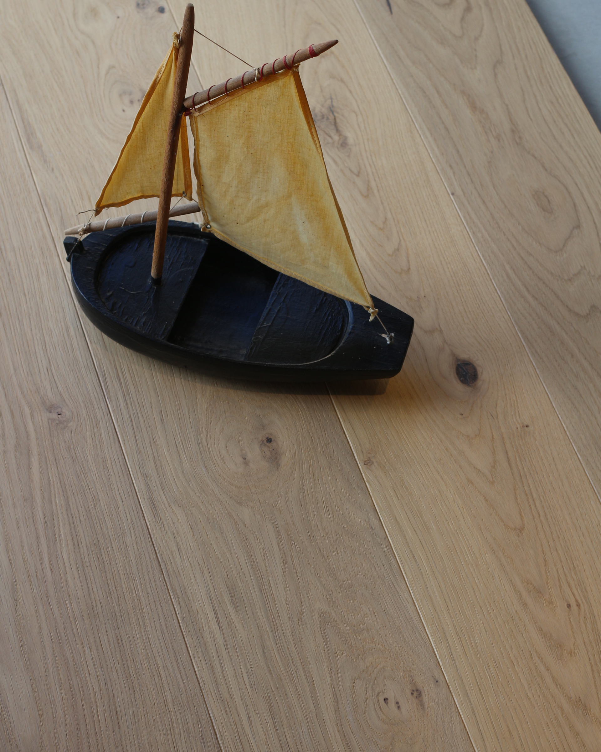 Gros plan sur des lames de parquet en bois clair avec des nœuds et des veinures bien visibles