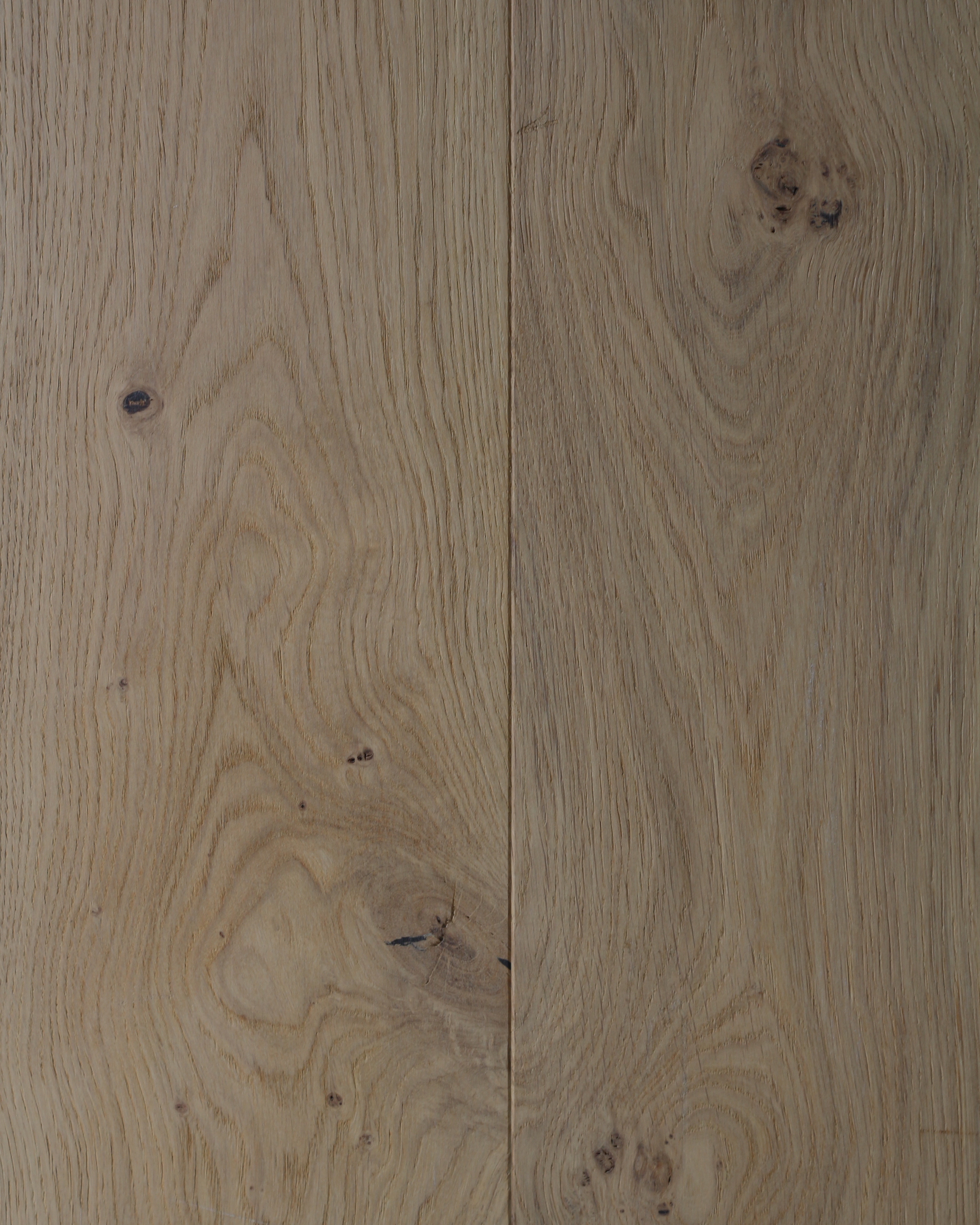 Gros plan sur des lames de parquet en bois clair avec des nœuds et des veinures bien visibles