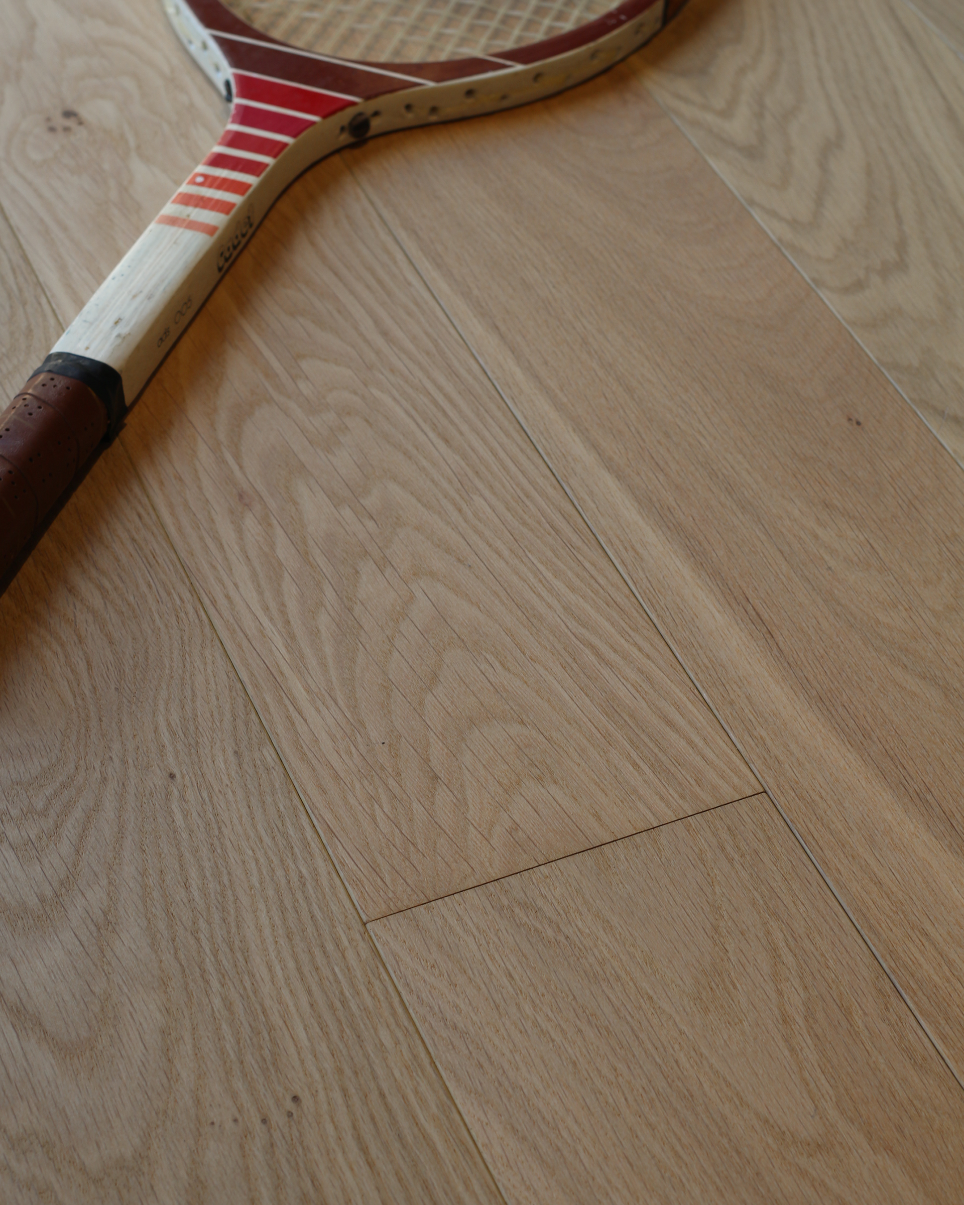 Gros plan sur le veinage d’un bois brun clair, avec un joint vertical entre les planches