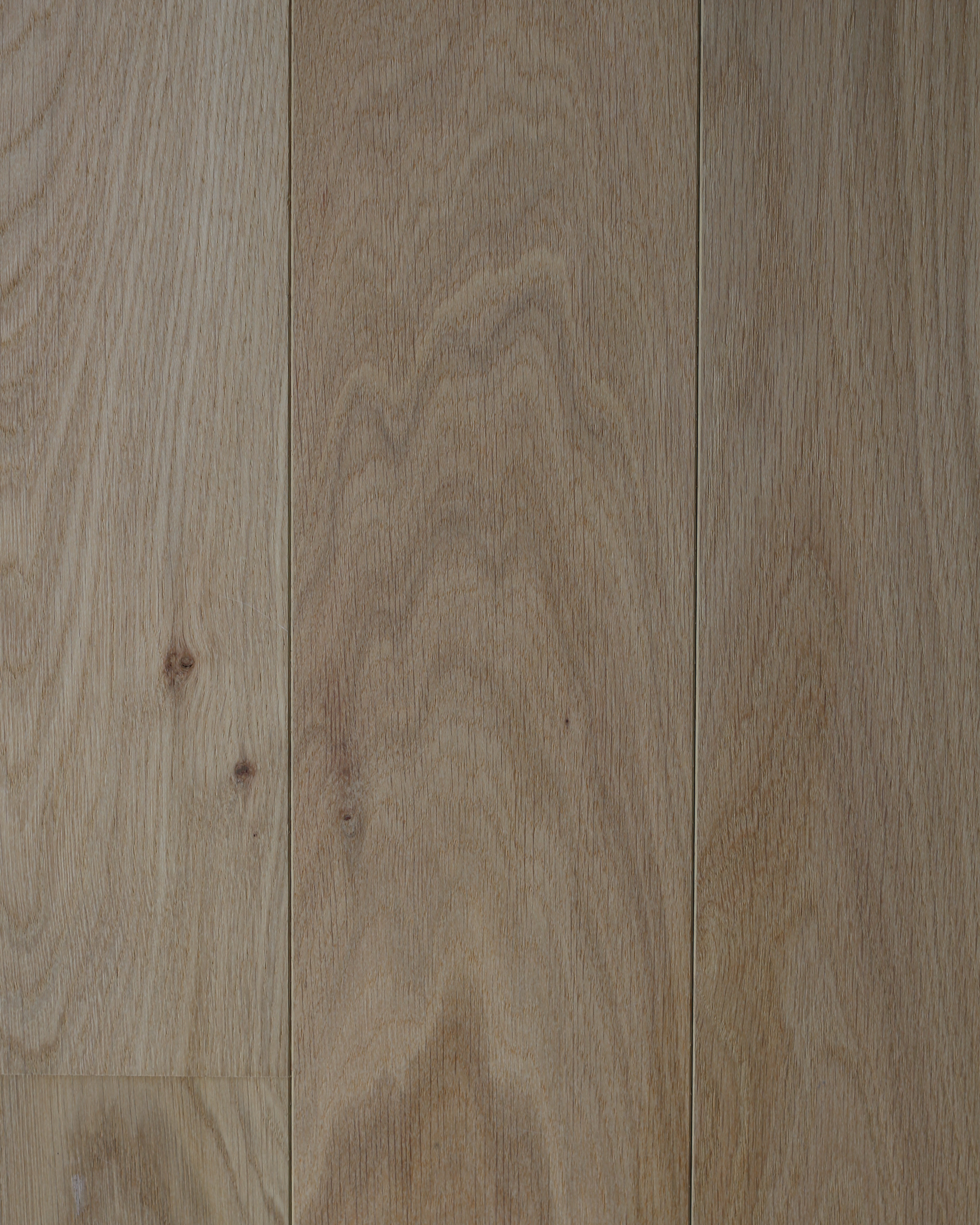Gros plan sur le veinage d’un bois brun clair, avec un joint vertical entre les planches
