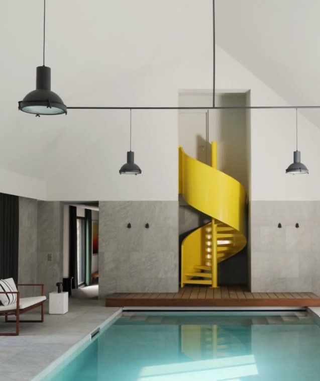 Piscine intérieure moderne avec un escalier en colimaçon jaune vif