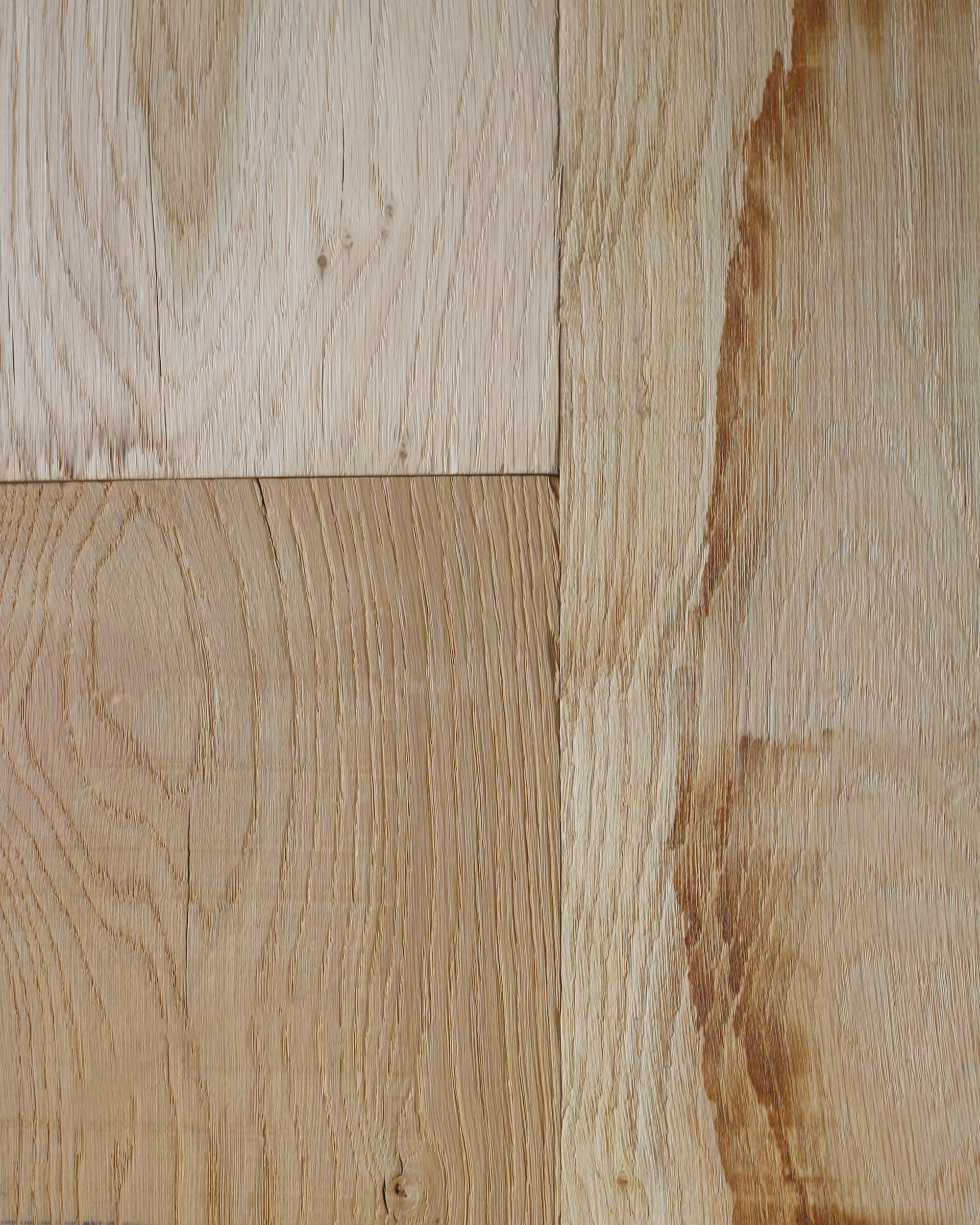 Gros plan sur des planches de bois brun clair patinées, avec leurs nœuds et leurs veines.