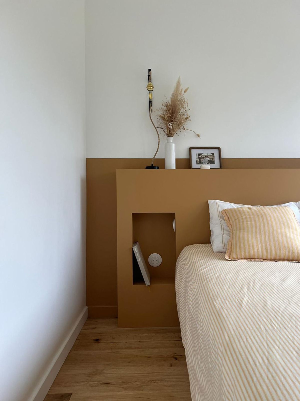 Coin de chambre minimaliste avec une étagère de tête de lit couleur fauve