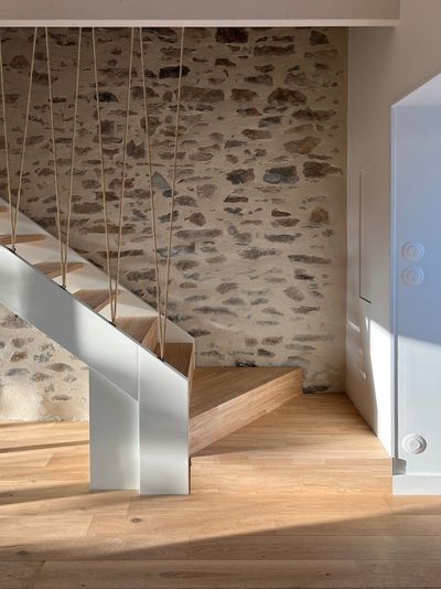 Escalier moderne baigné de lumière, avec une rampe en métal blanc