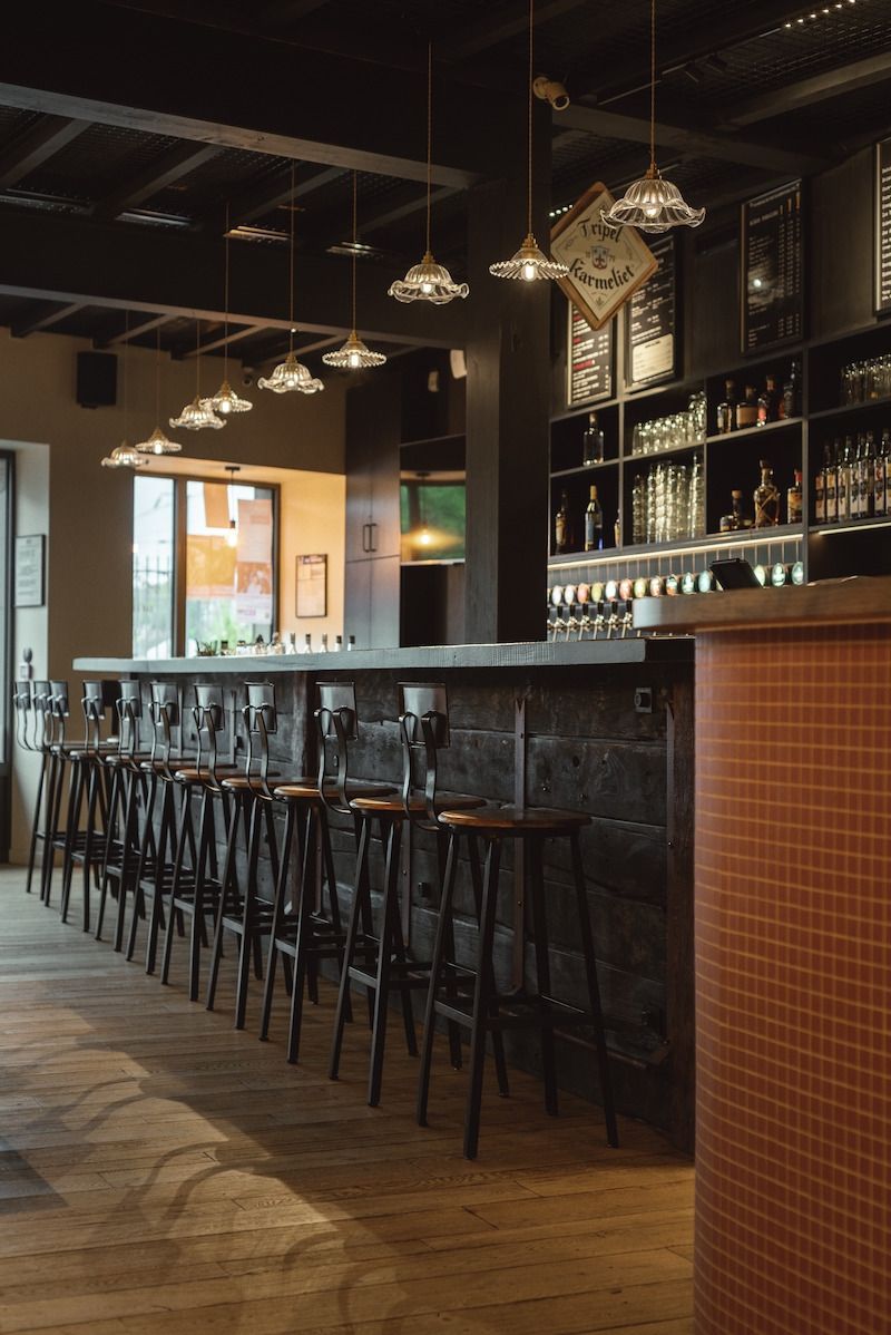 Intérieur de bar faiblement éclairé, avec des tabourets noirs