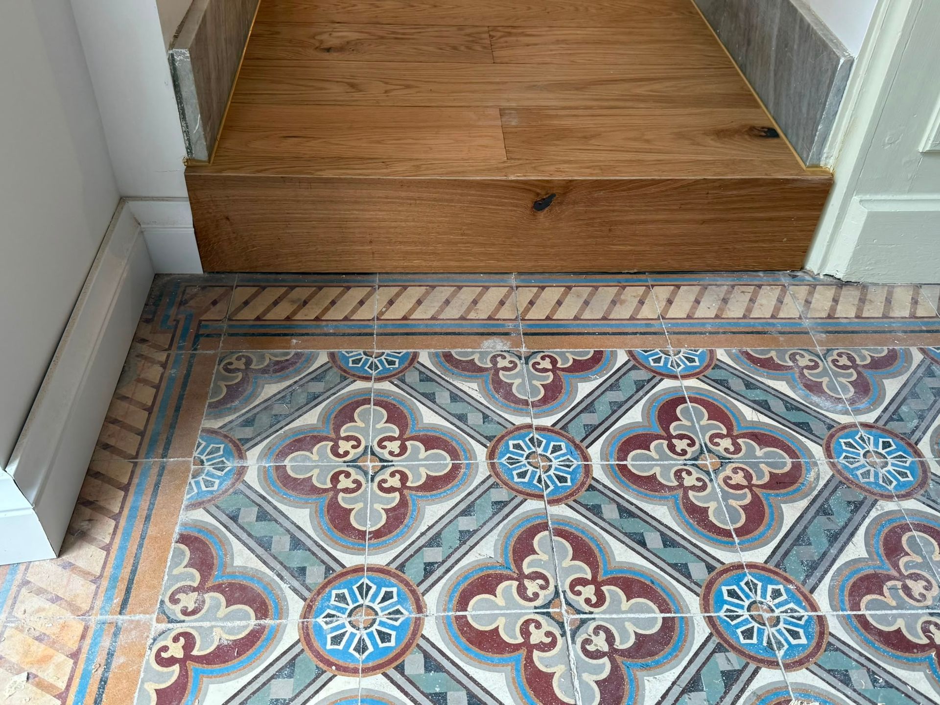 Sol à motifs rejoignant le parquet du couloir au niveau d’une porte