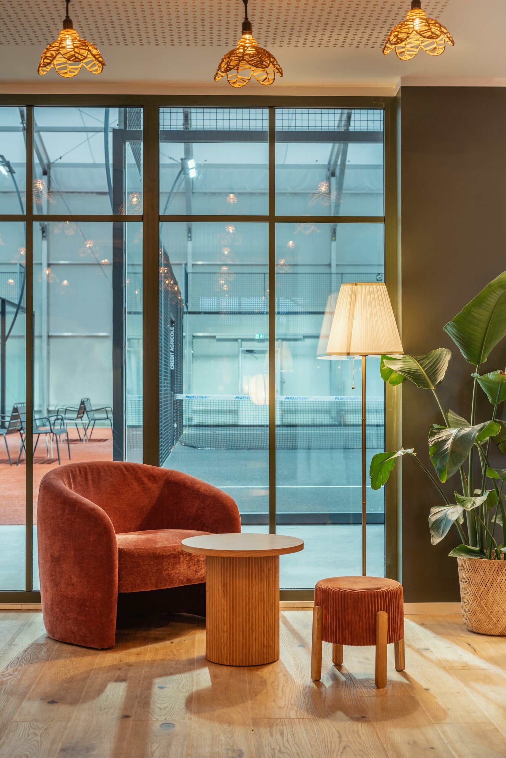 Salon cosy avec un fauteuil rouge, des tables en bois