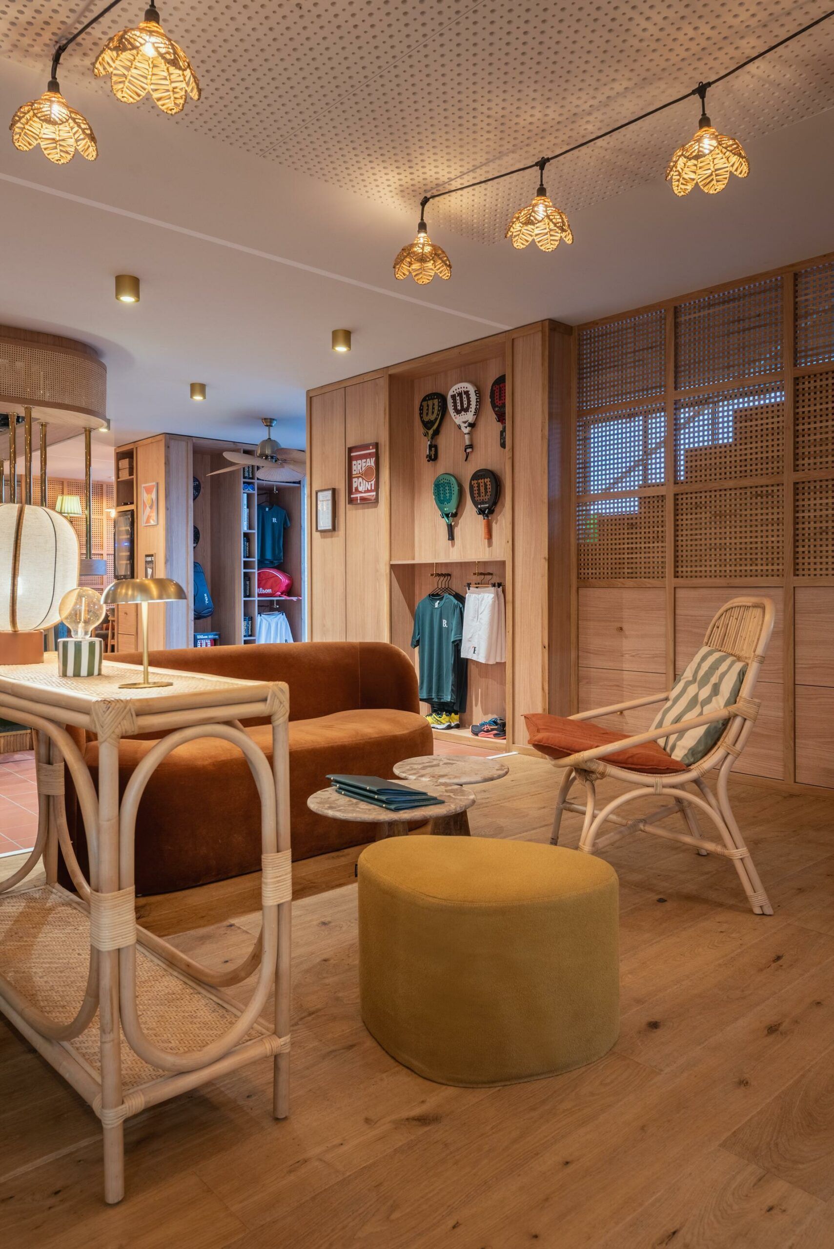 Salon bohème chaleureux avec des fauteuils en rotin, des suspensions lumineuses chaleureuses et un pouf jaune