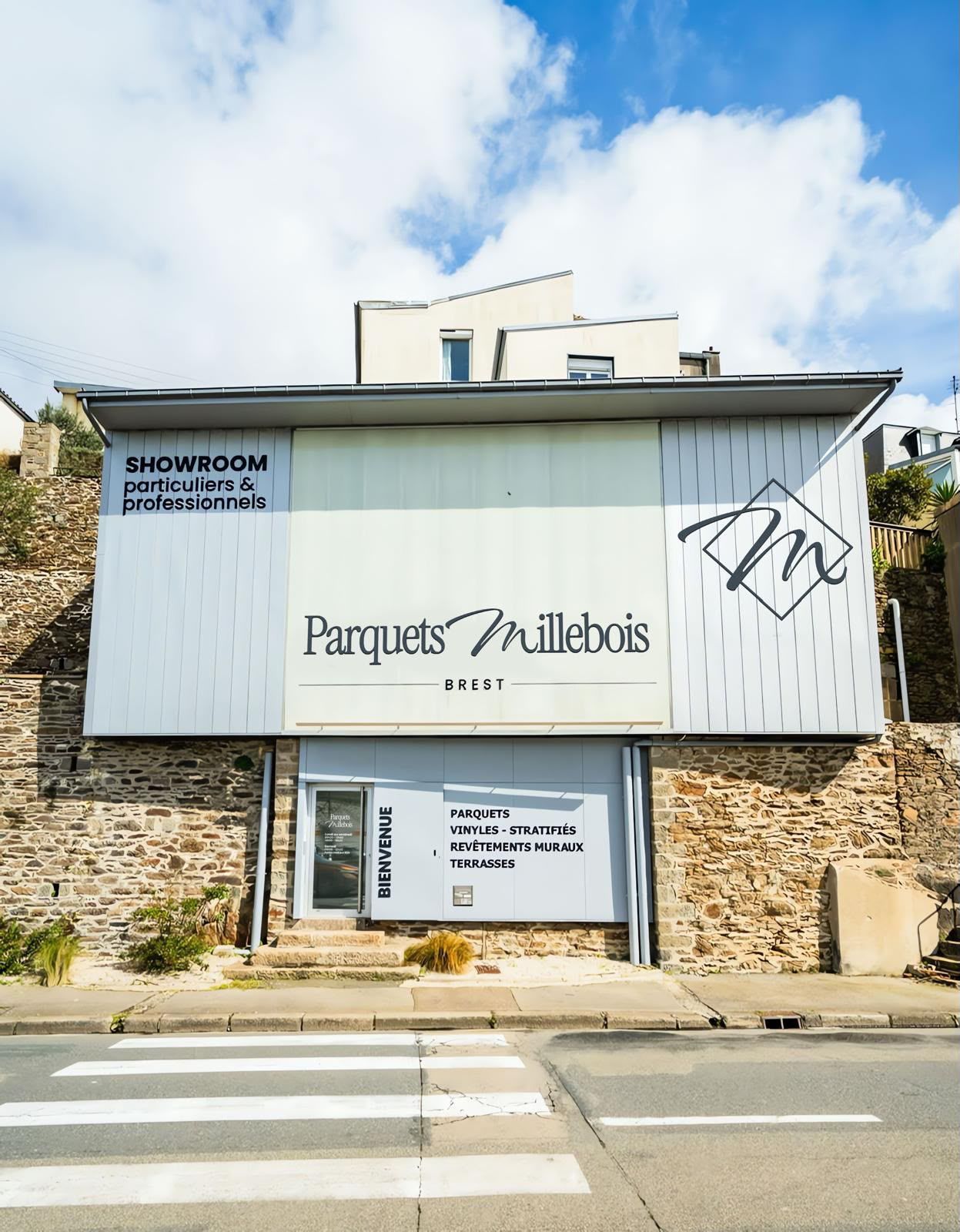 Devanture avec une façade en pierre et une grande enseigne blanche