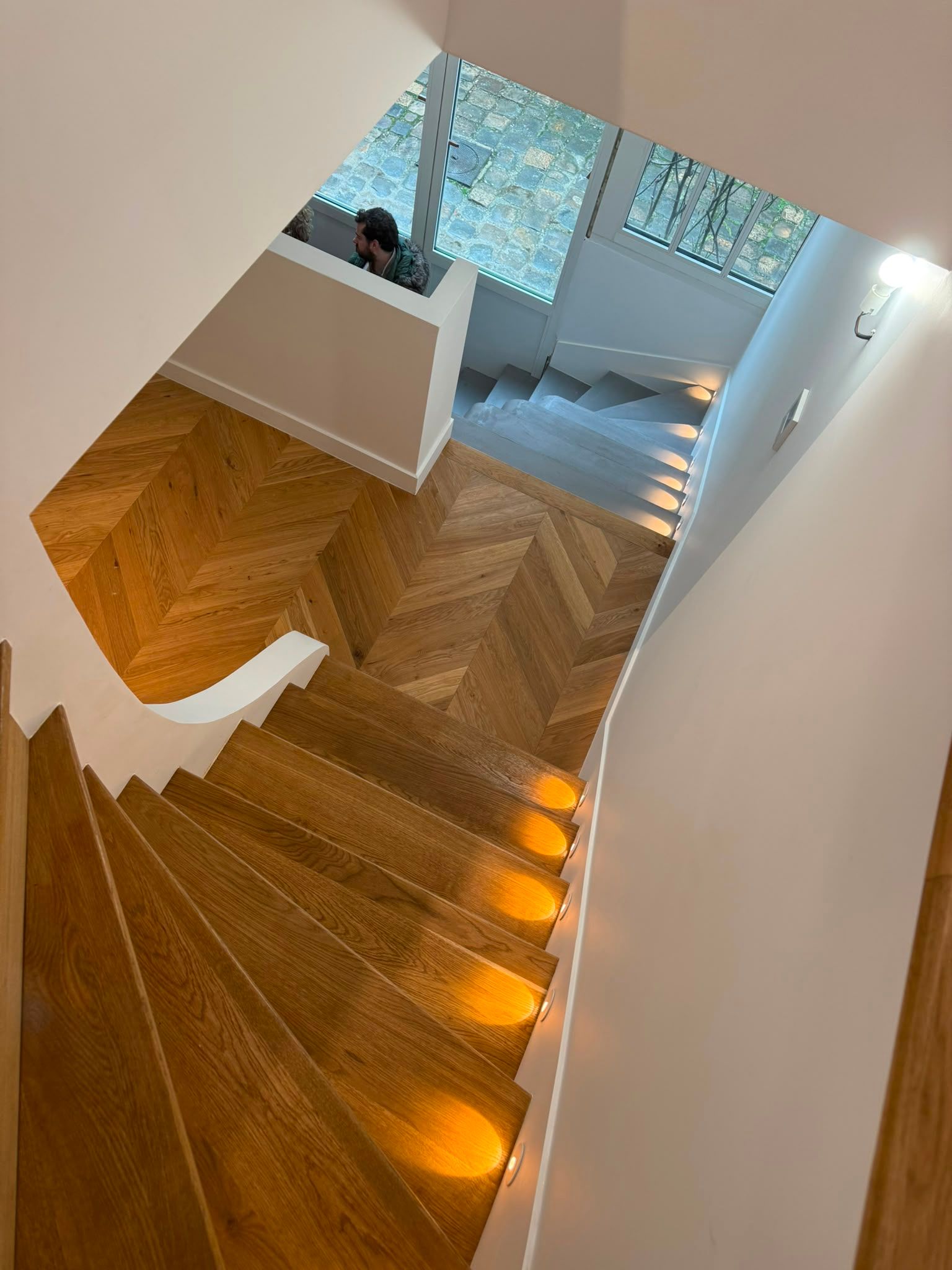 Escalier en bois incurvé avec des éclairages orange intégrés aux marches