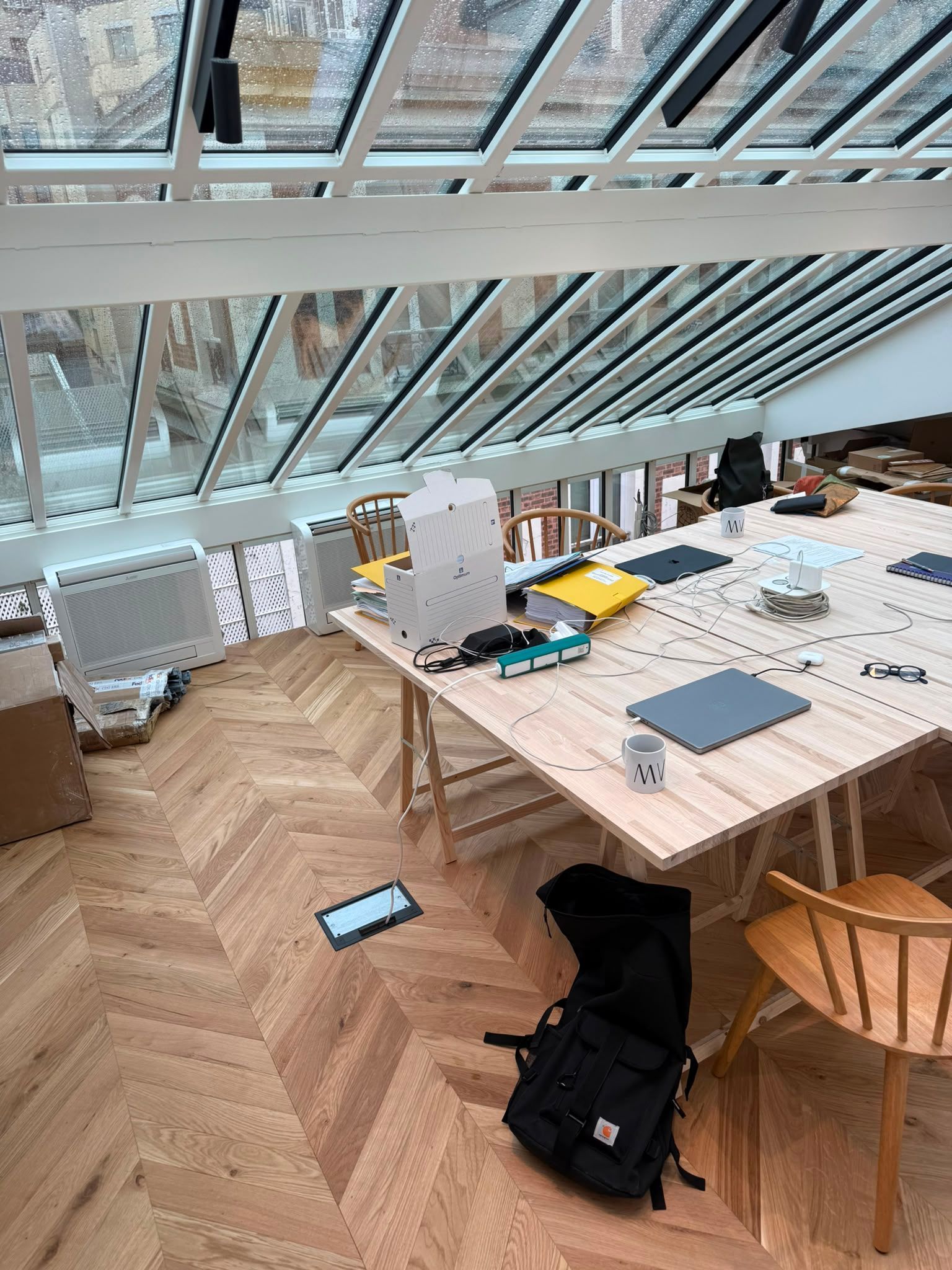 Espace de travail lumineux sous les toits, avec de grandes fenêtres en biais