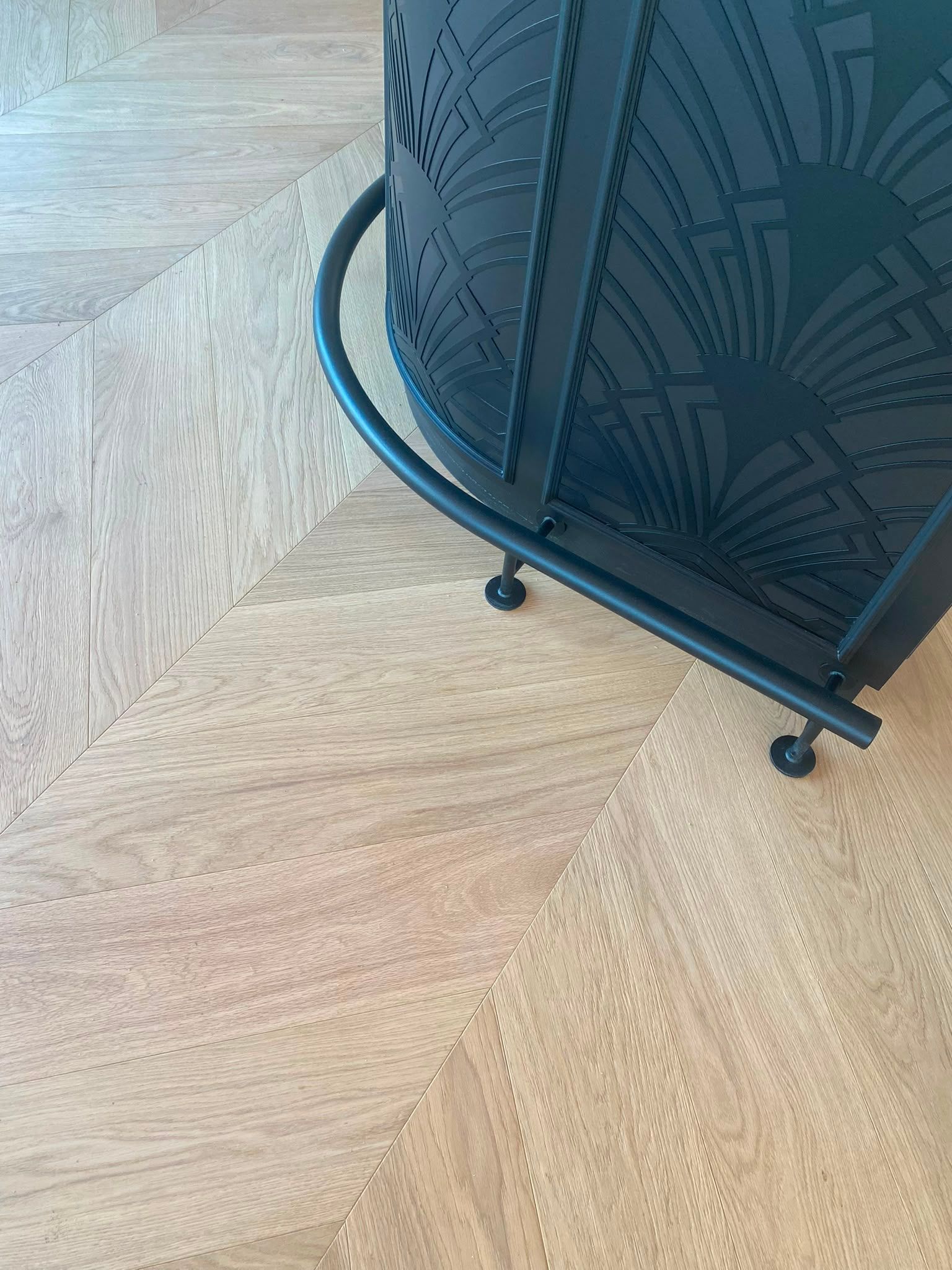 Armoire décorative en métal noir ou pare-feu sur un parquet clair, vue rapprochée
