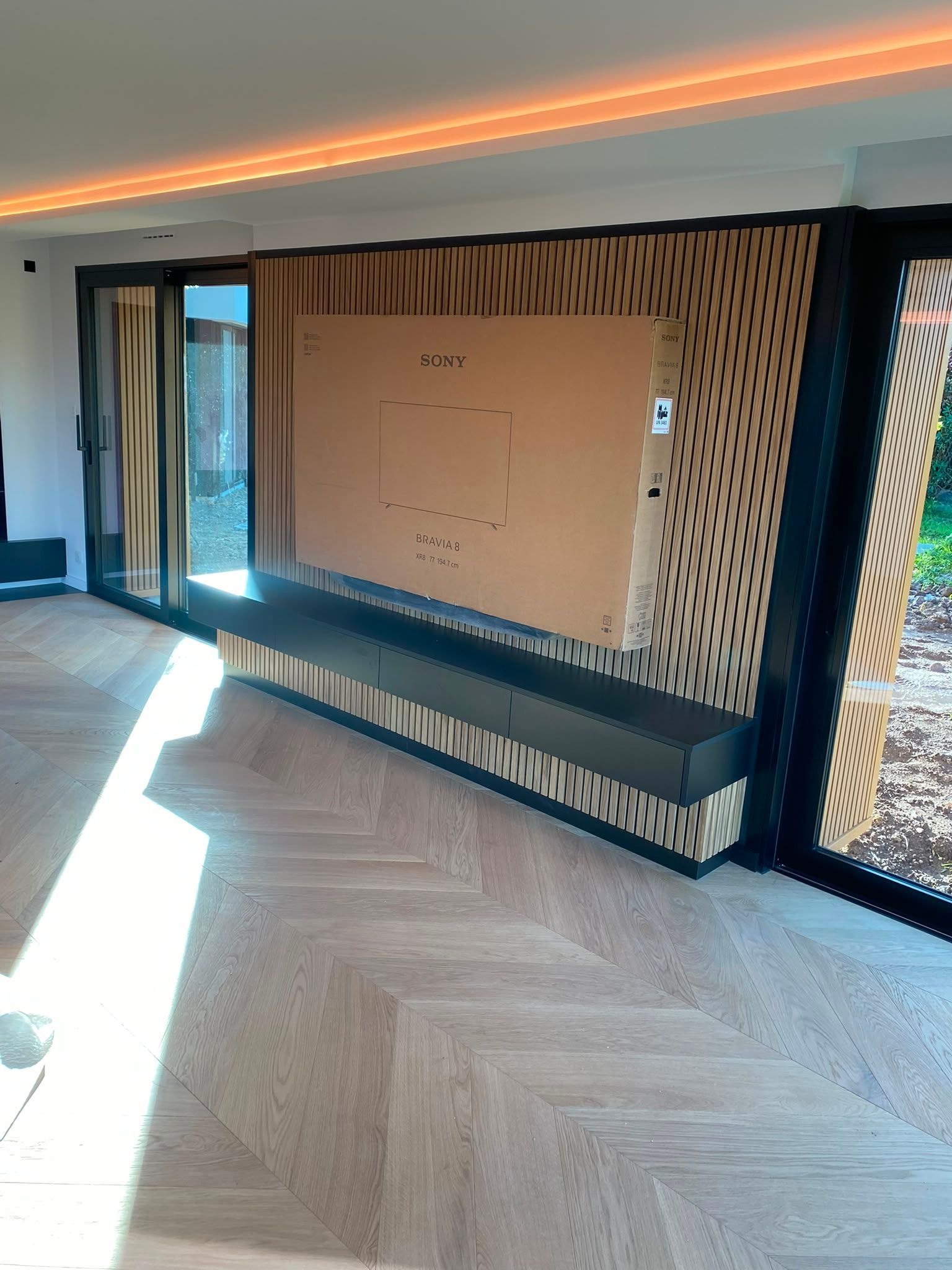 Mur intérieur moderne avec un motif abstrait noir et crème et un éclairage LED chaleureux au plafond