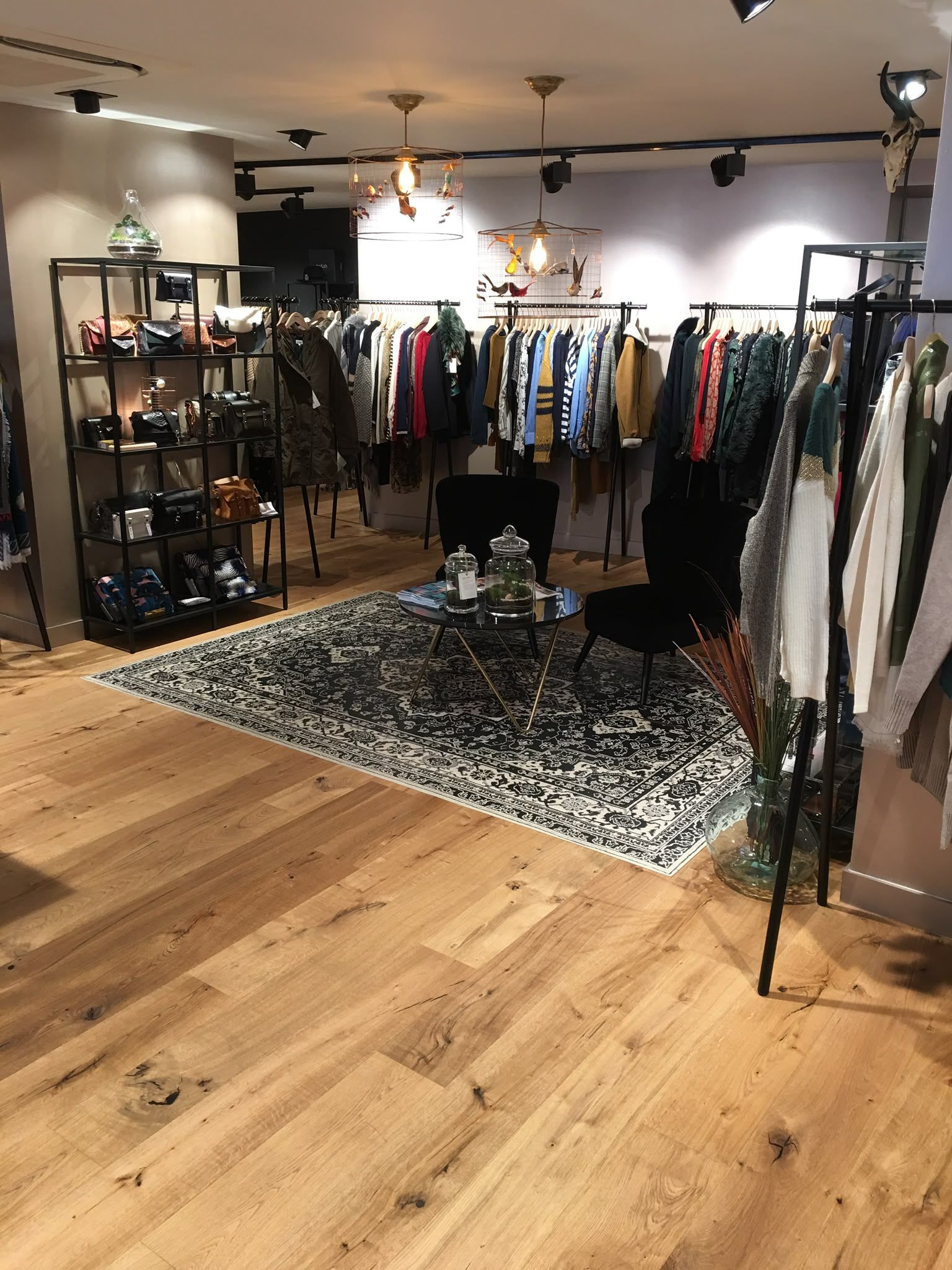 Boutique de vêtements avec des portants remplis de vêtements colorés
