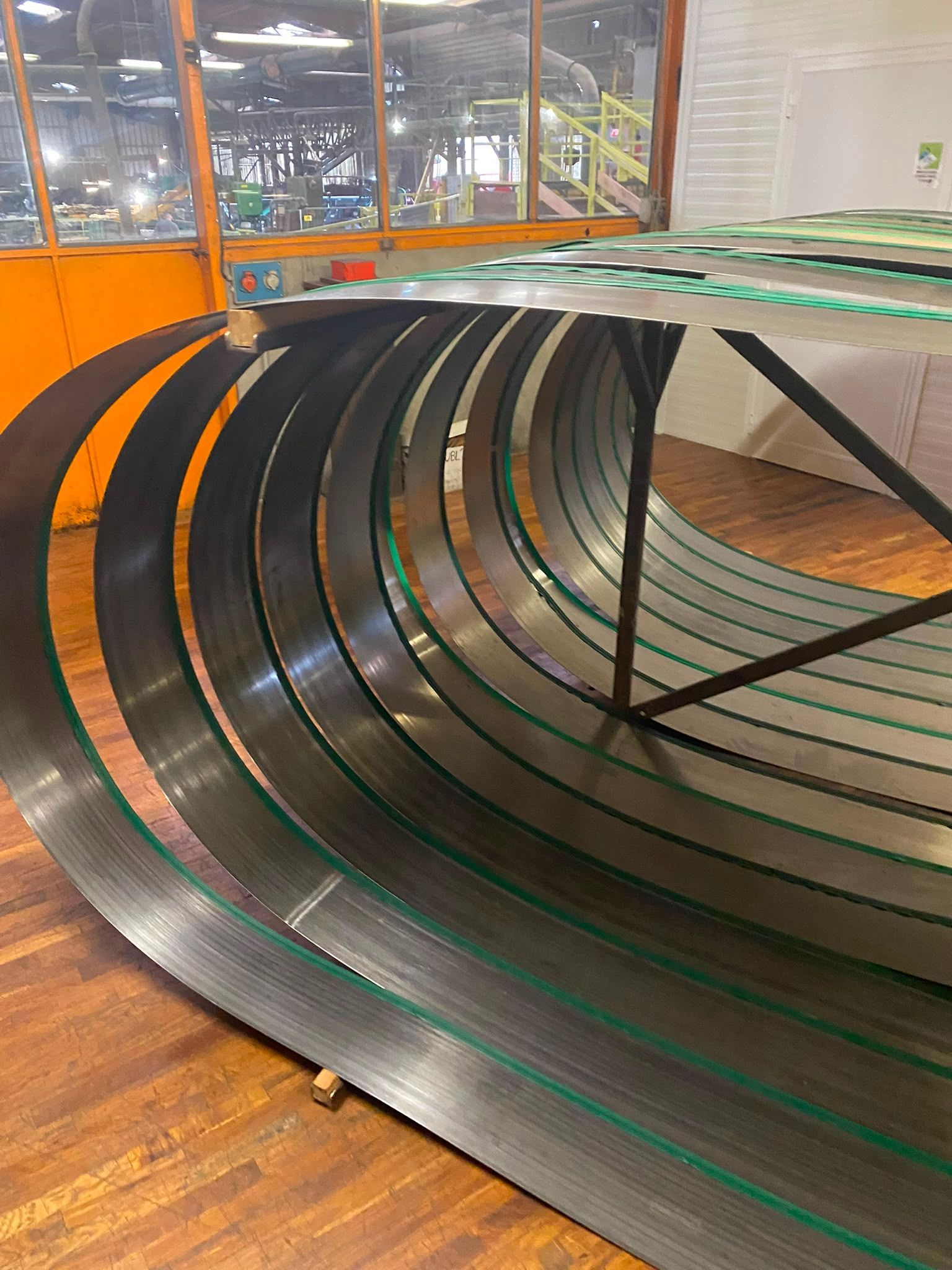 Tunnel de convoyage noir avec des panneaux latéraux orange dans un environnement industriel intérieur