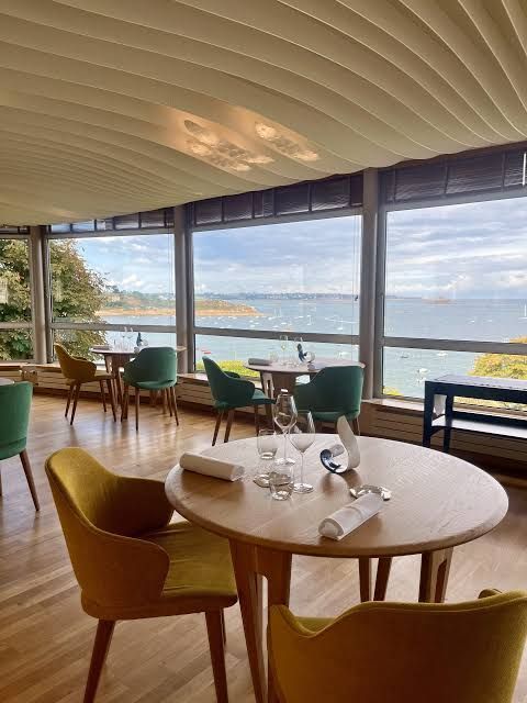 Restaurant moderne avec des tables rondes et des chaises vertes