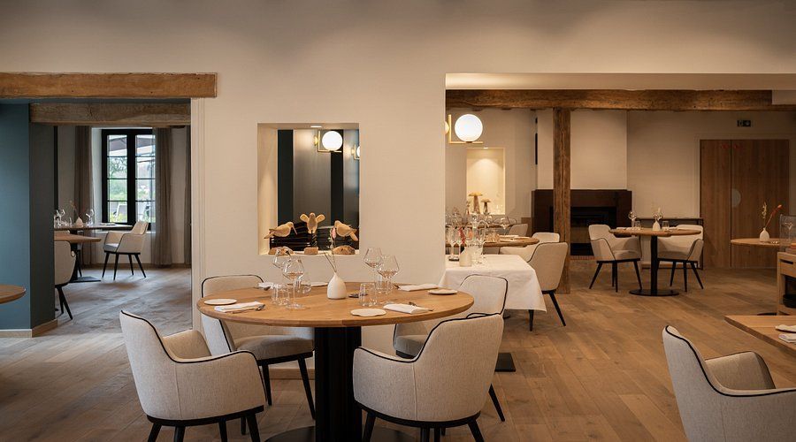 Salle à manger chaleureuse et minimaliste, avec des tables rondes