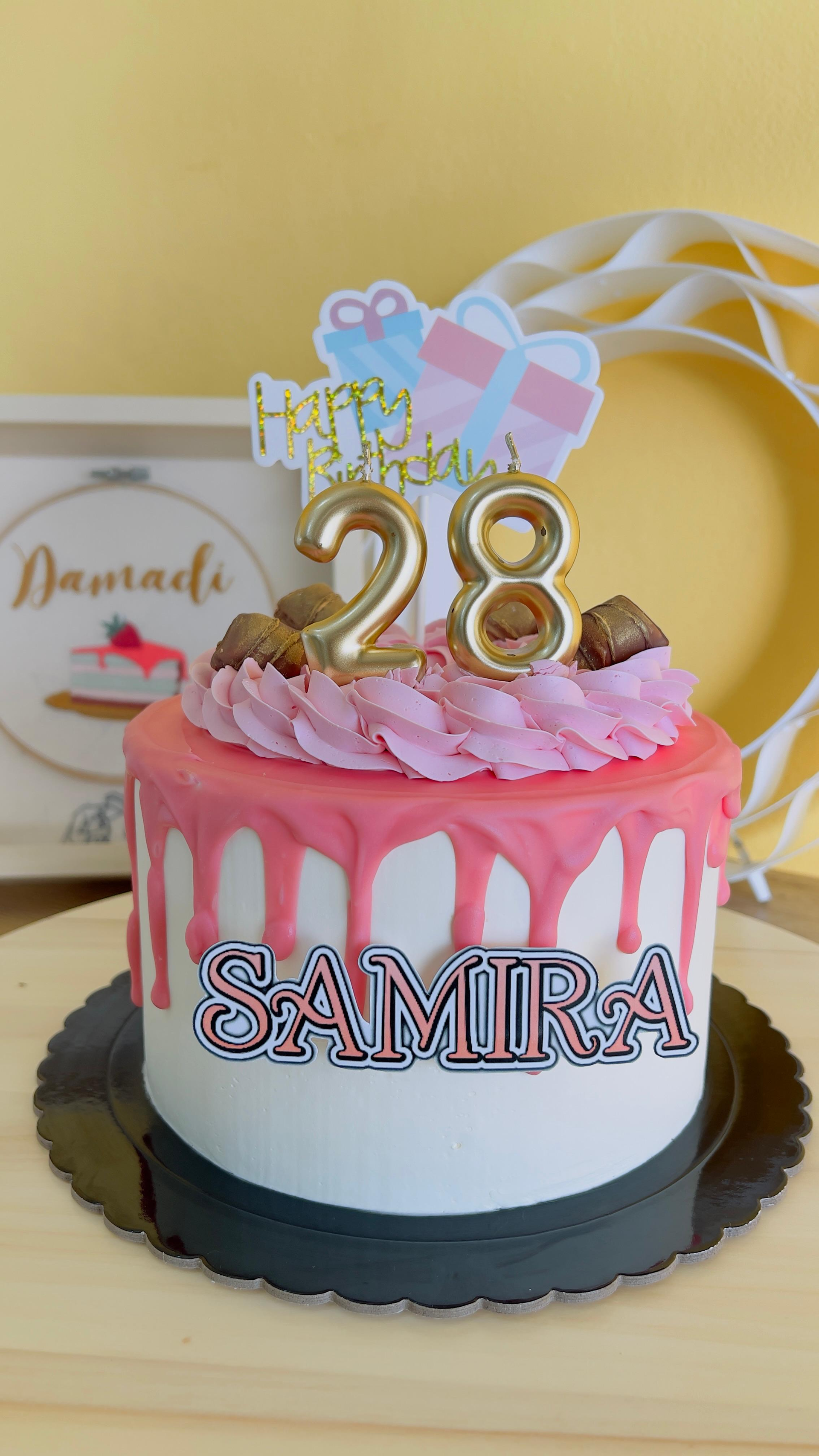 Tarta de cumpleaños rosa y blanca con un adorno dorado con el número 