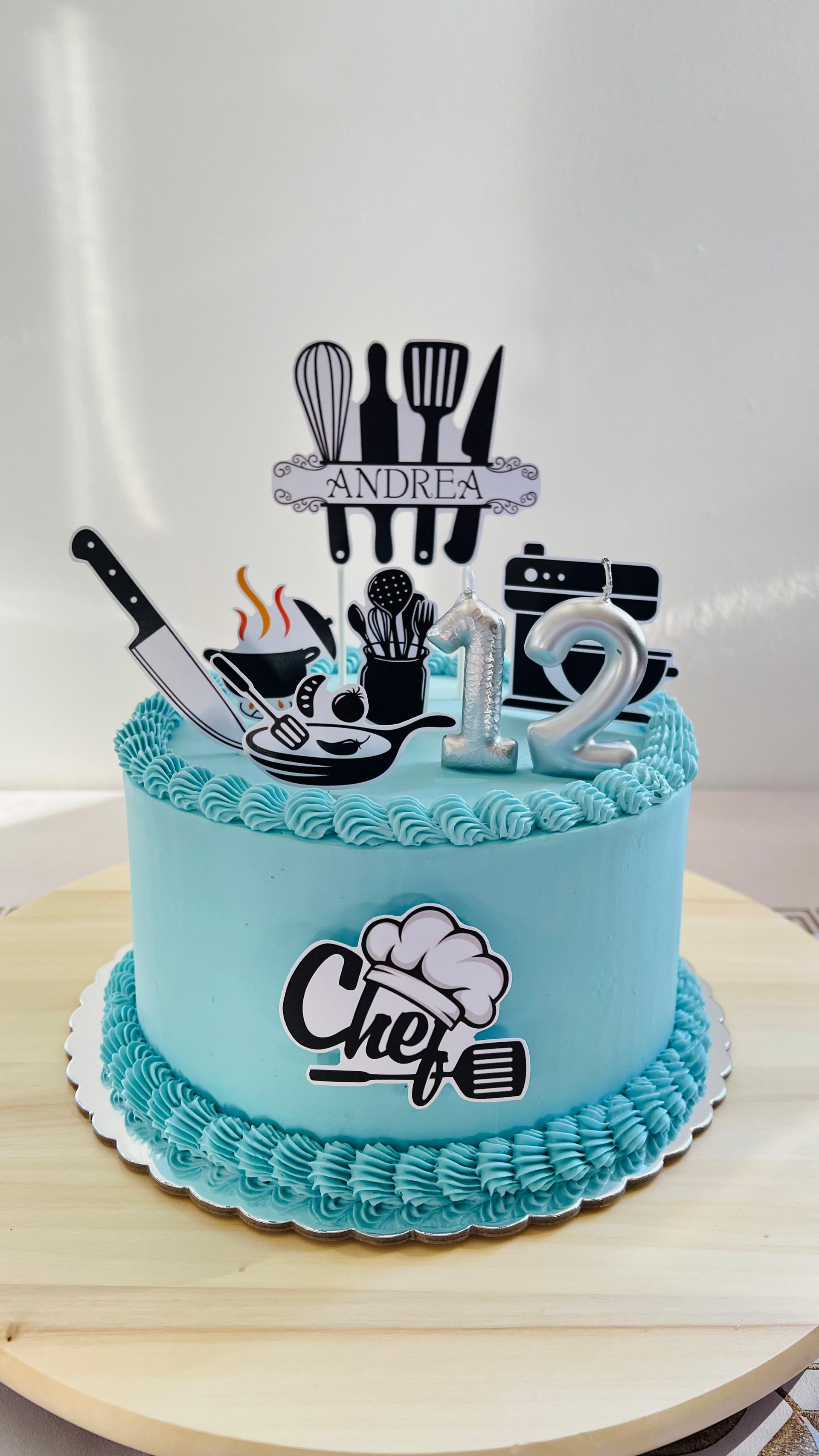 Tarta turquesa con adornos de temática barbería: tijeras, peines y una decoración en negro y plateado con la palabra 