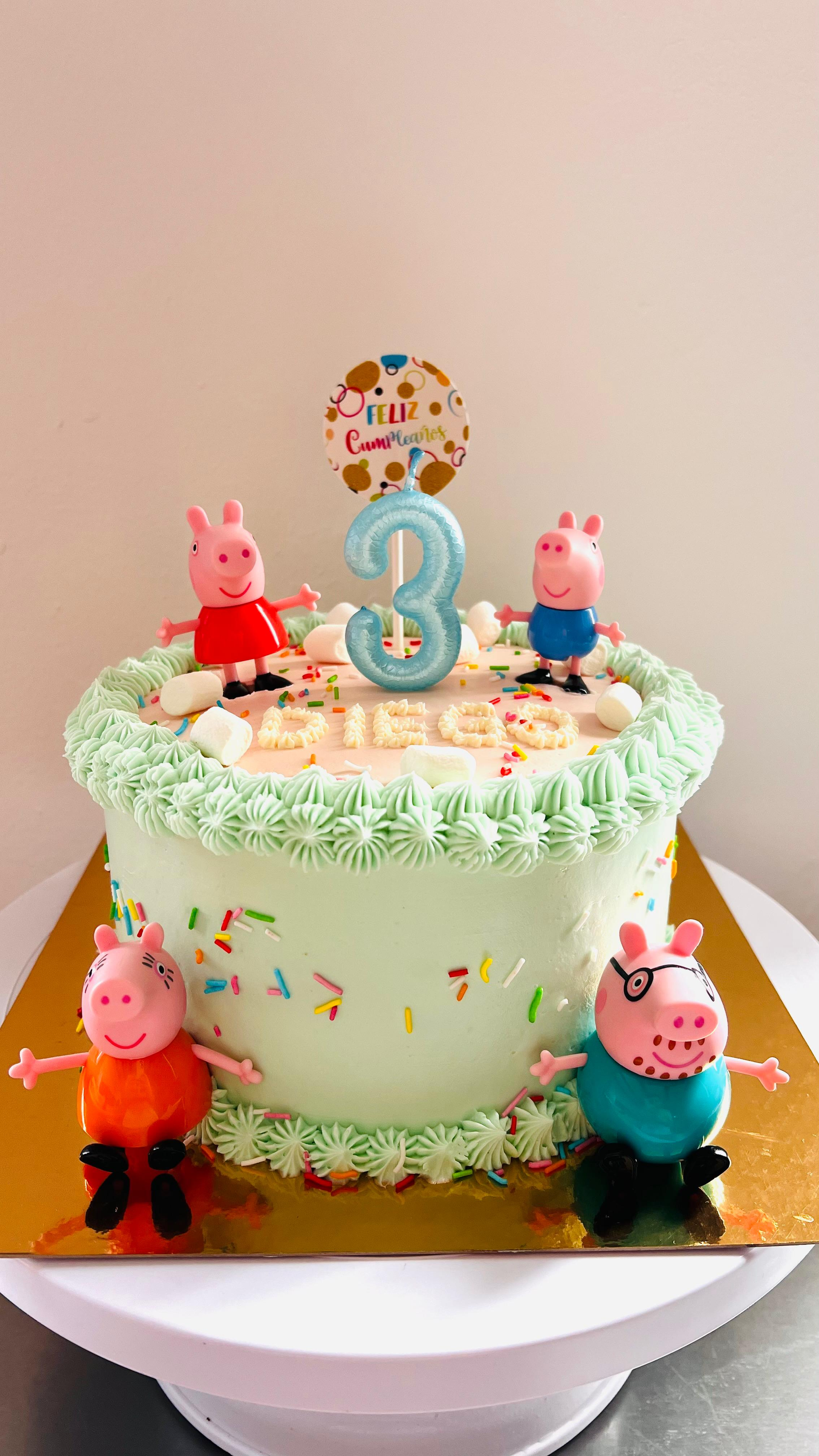 Tarta de cumpleaños de Peppa Pig con un adorno azul con el número 