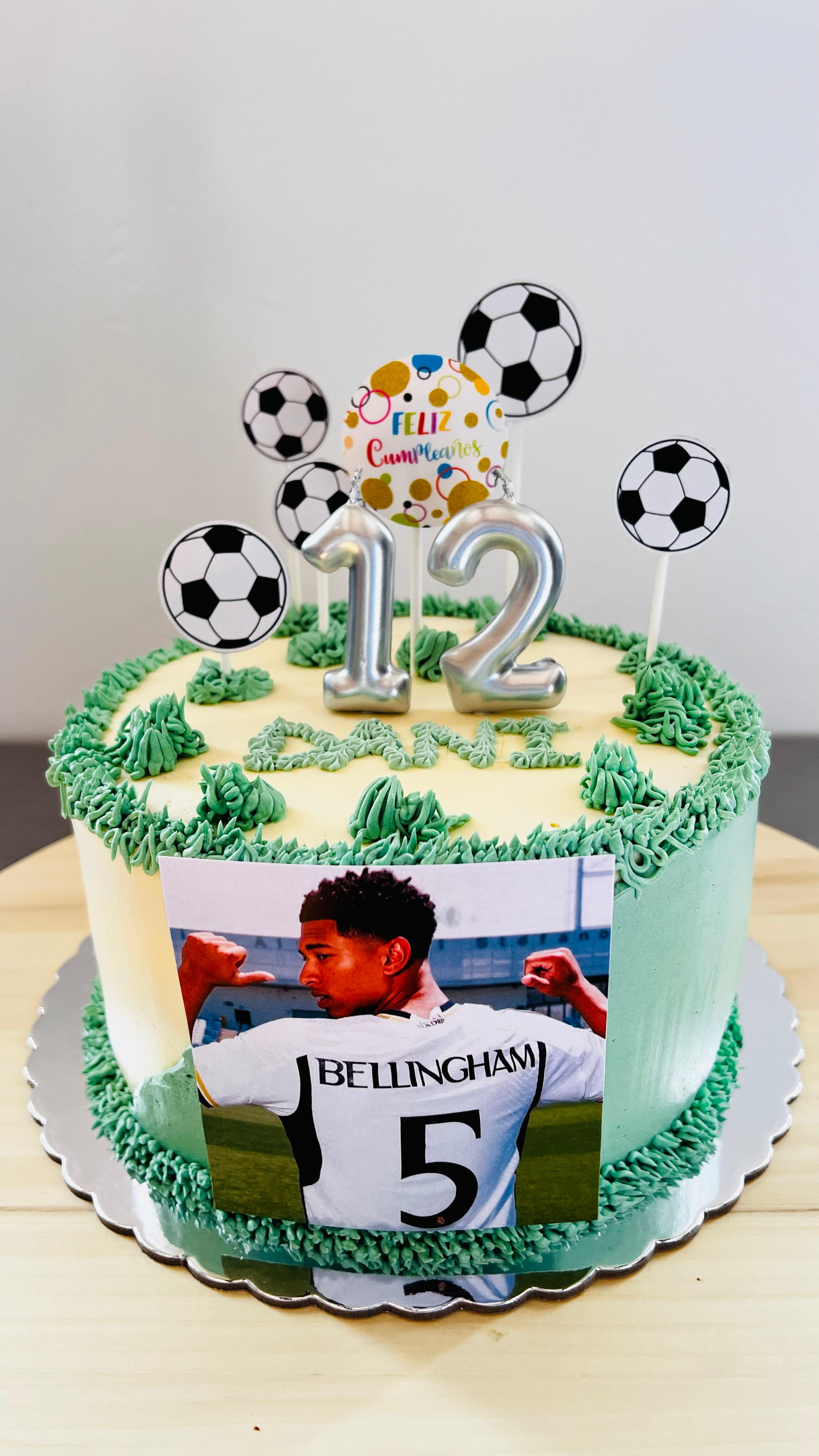 Tarta de cumpleaños con temática futbolística, glaseado verde, adorno con el número 12.