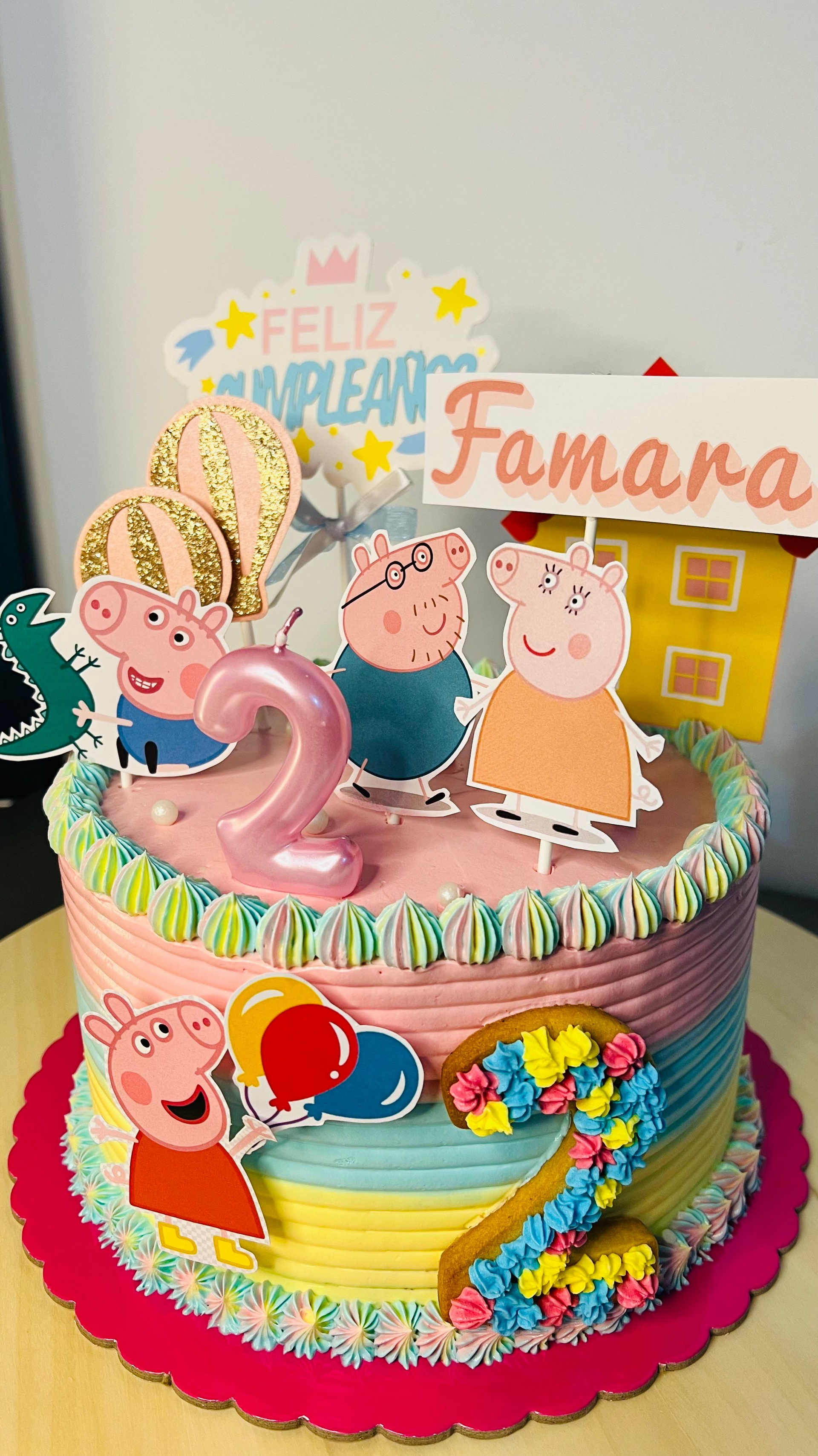 Tarta de cumpleaños colorida con temática de Peppa Pig, glaseado arcoíris, un gran número 2 rosa y un adorno de 