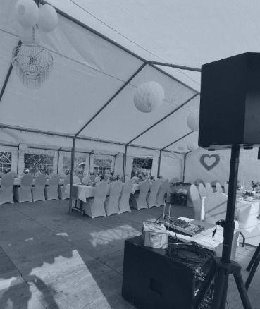 Ein Schwarzweißfoto eines Zeltes mit Tischen und Stühlen