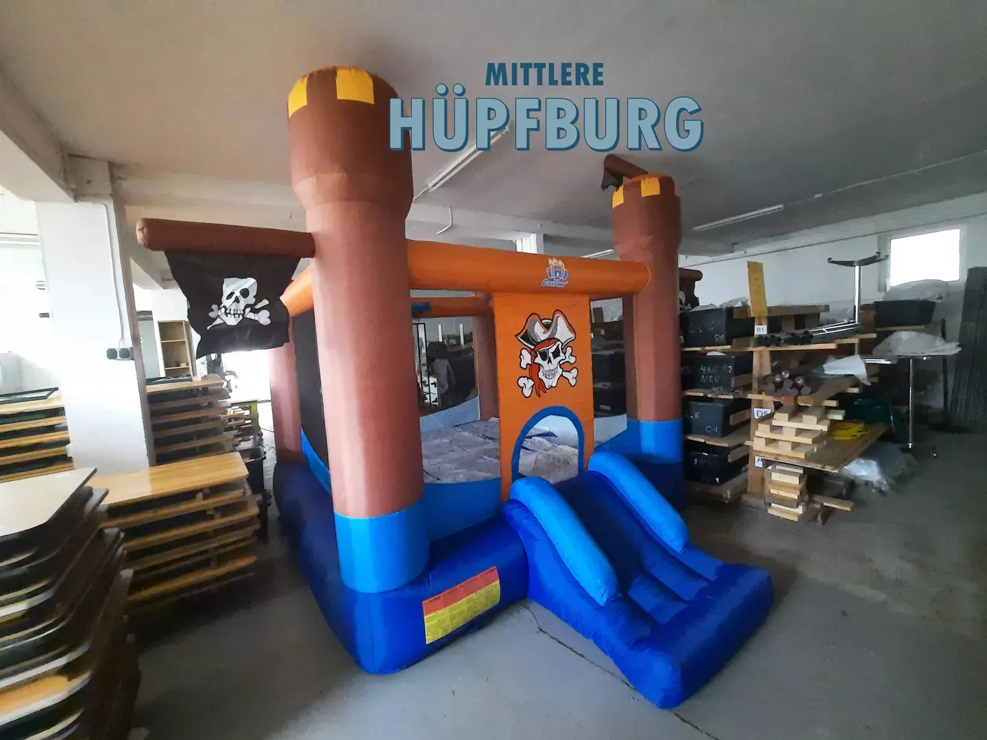 Eine aufblasbare Piratenburg mit Rutsche in einer Lagerhalle