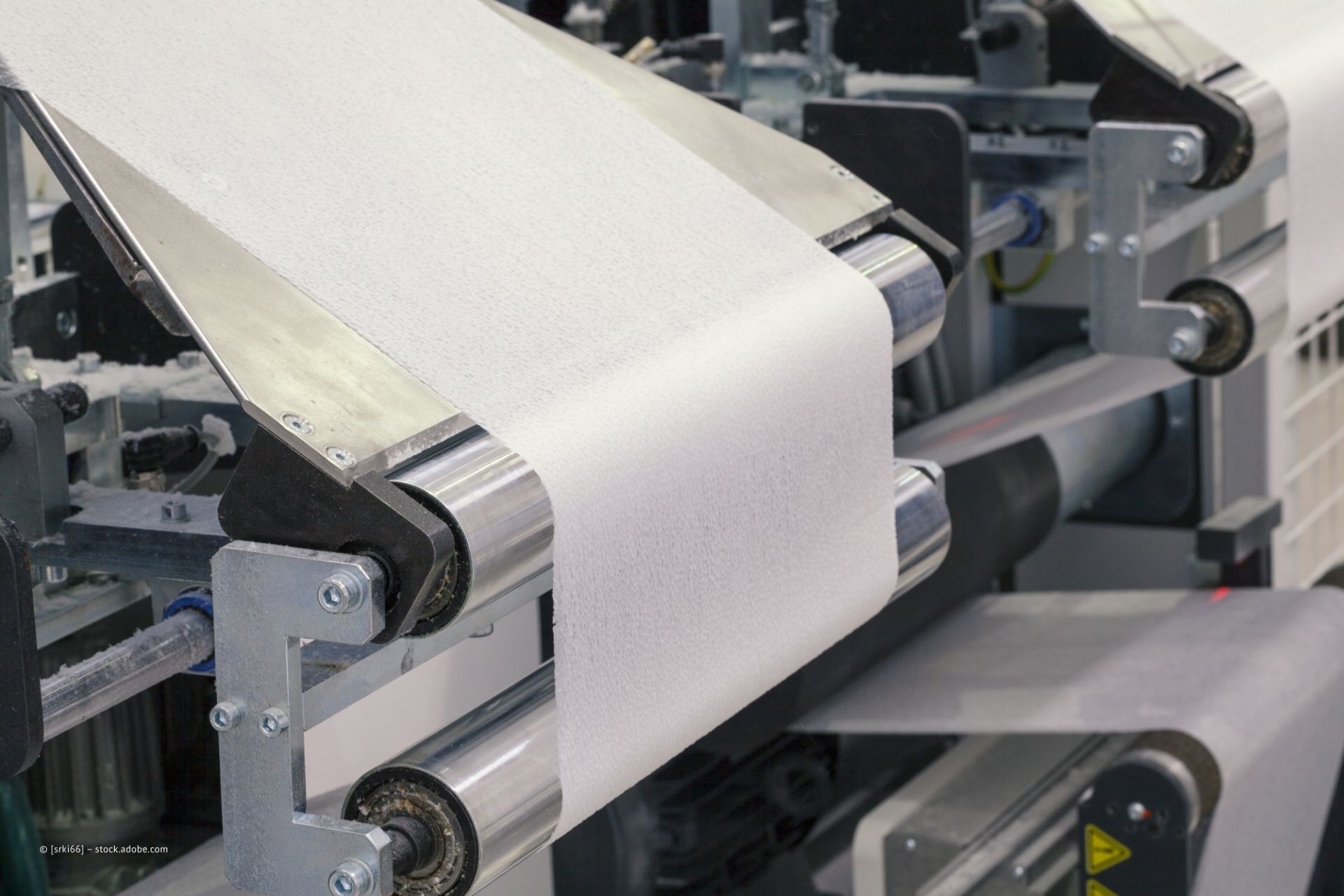 Weißes Papier rollt durch einen großen Drucker