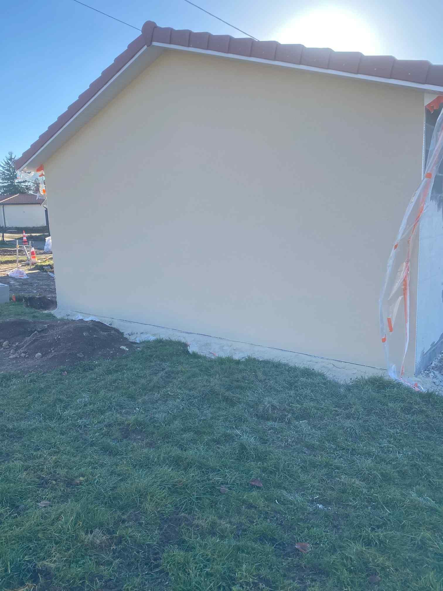 Côté d'une maison beige aux boiseries blanches