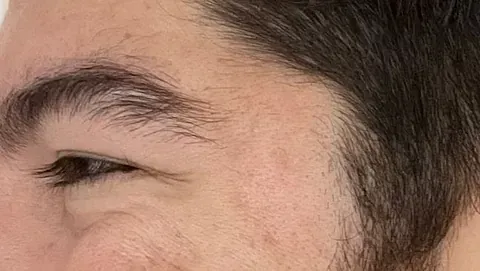 Un primer plano de la cara de un hombre con barba y cejas.