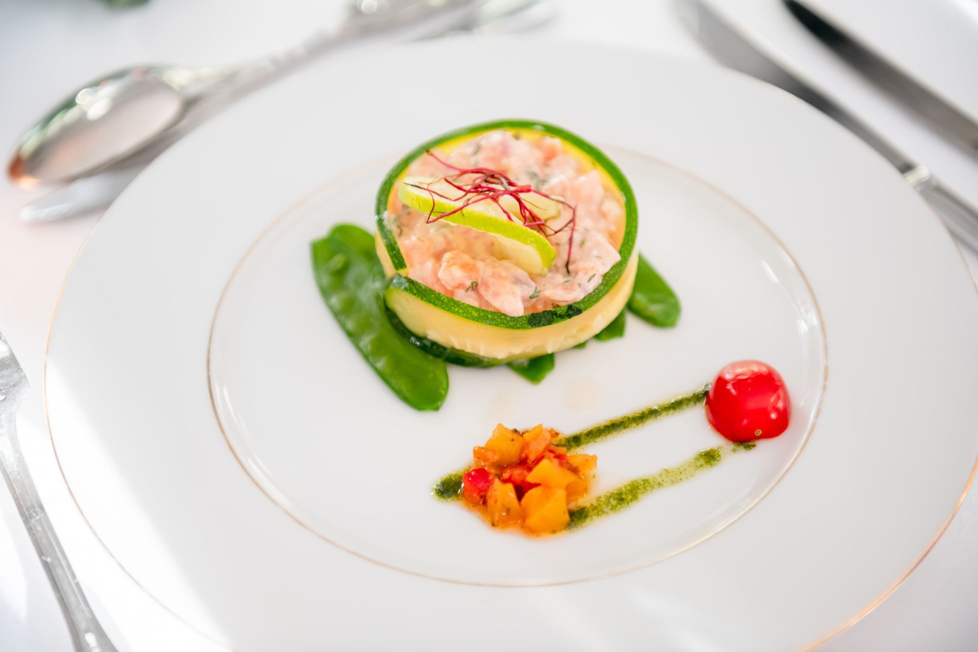 Assiette avec une courgette roulée et une tomate cerise