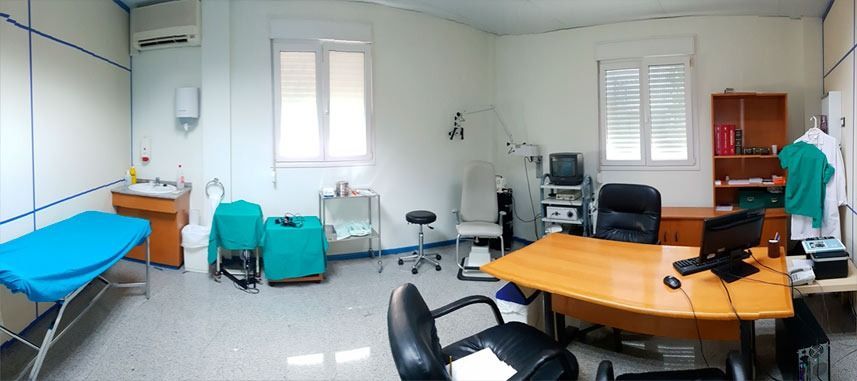 Un consultorio médico con un escritorio y sillas