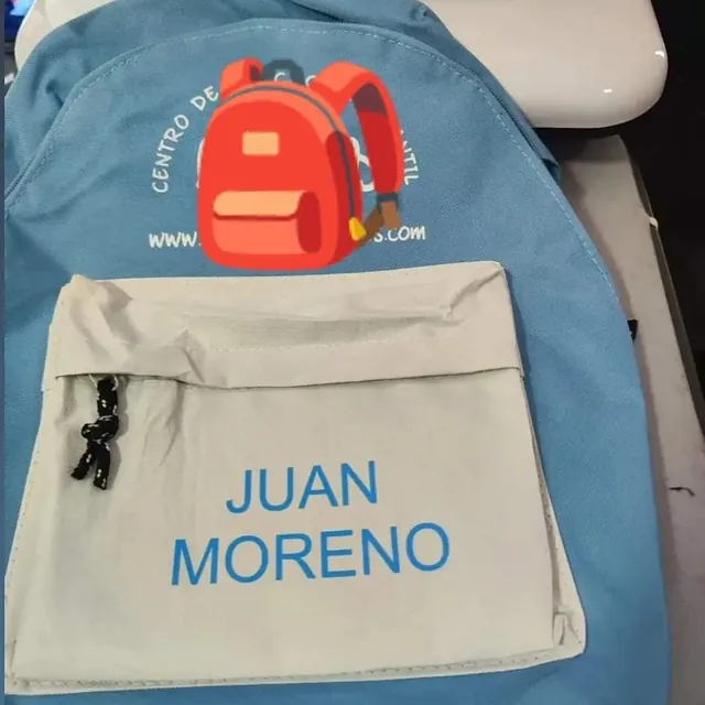 Una mochila azul con el nombre Juan Moreno.