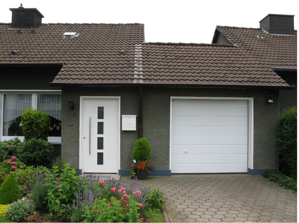 Weiße Hautür neben weißem Garagentor
