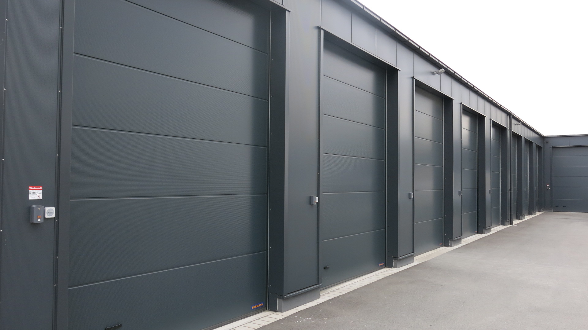 Mehrere Rolltorgaragen nebeneinander mit schwarzer Fassade
