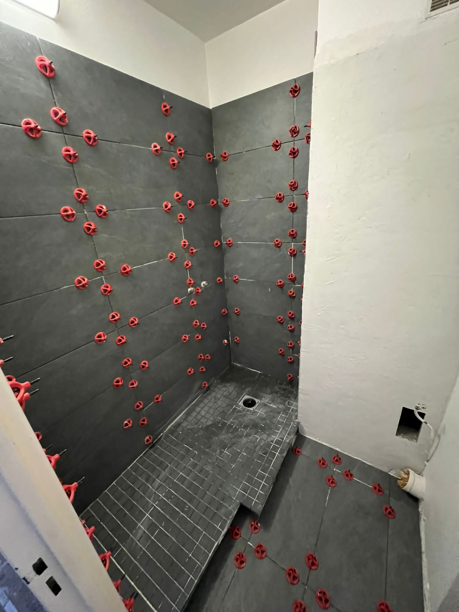 Pose de grand carrelage gris pour une douche