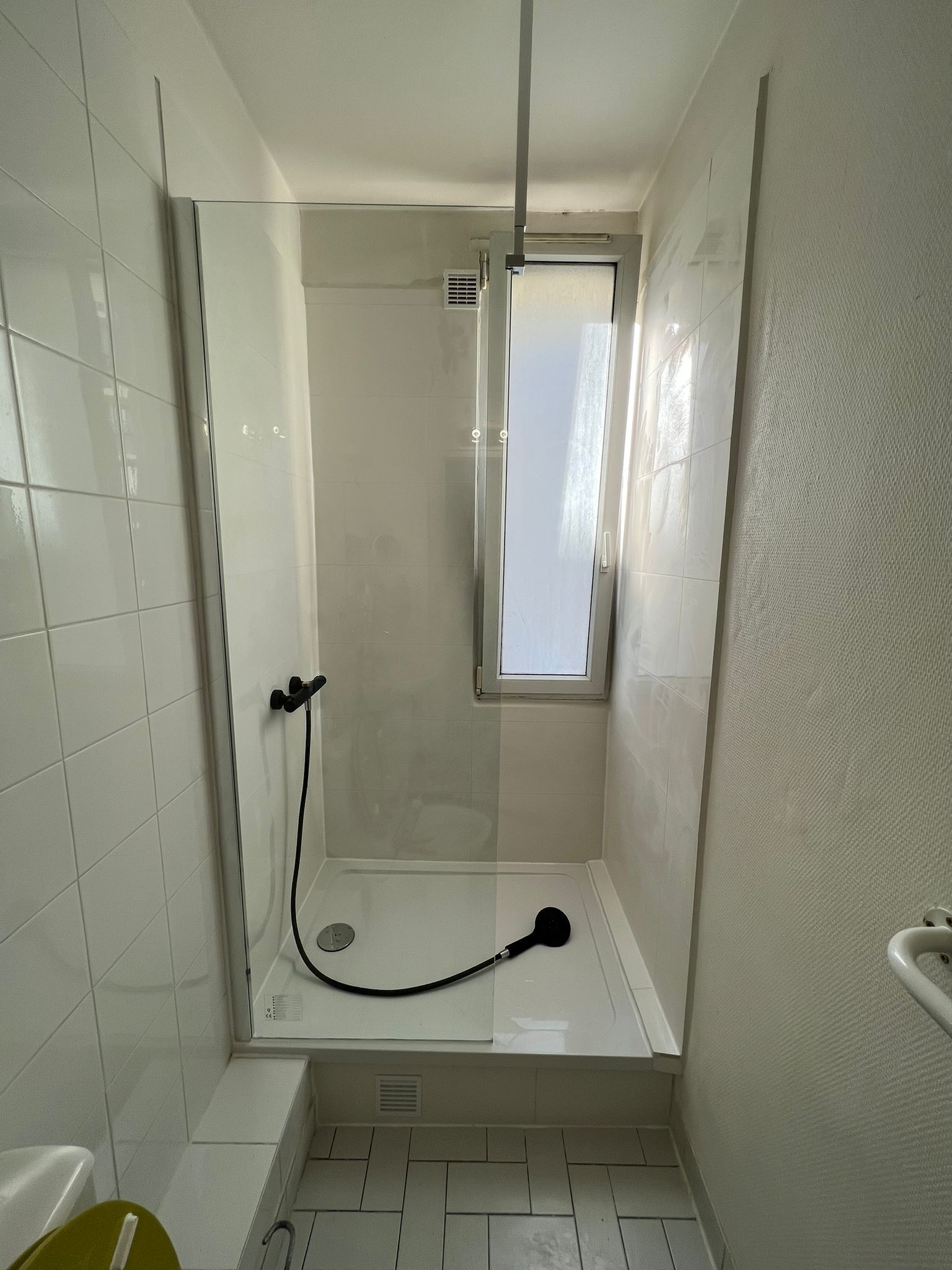 Douche blanche installée avec une fenêtre