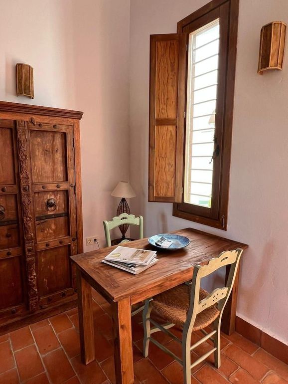 Una mesa y sillas de madera en una habitación con ventana.