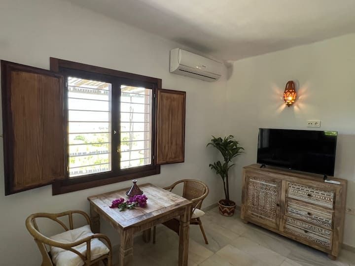 Una sala de estar con una mesa y sillas y un televisor de pantalla plana.