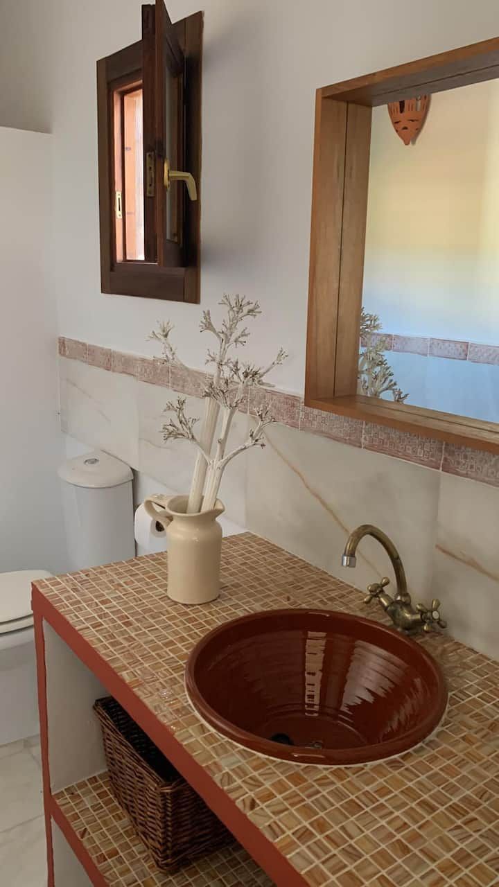 Un baño con lavabo, inodoro y espejo.